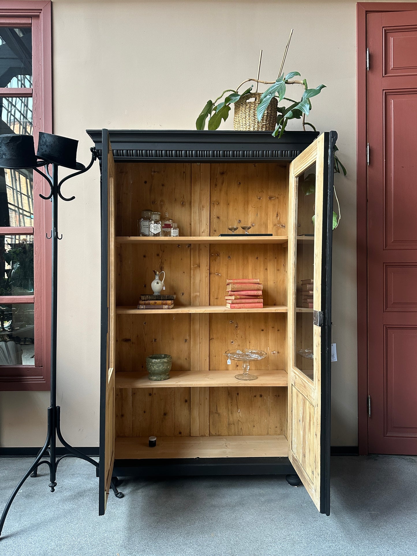 Ett gammalt klassiskt vitrinskåp med vackra detaljer såsom spår i sidorna, dekorationer i hörnen samt ett vackert utsmyckat krön.