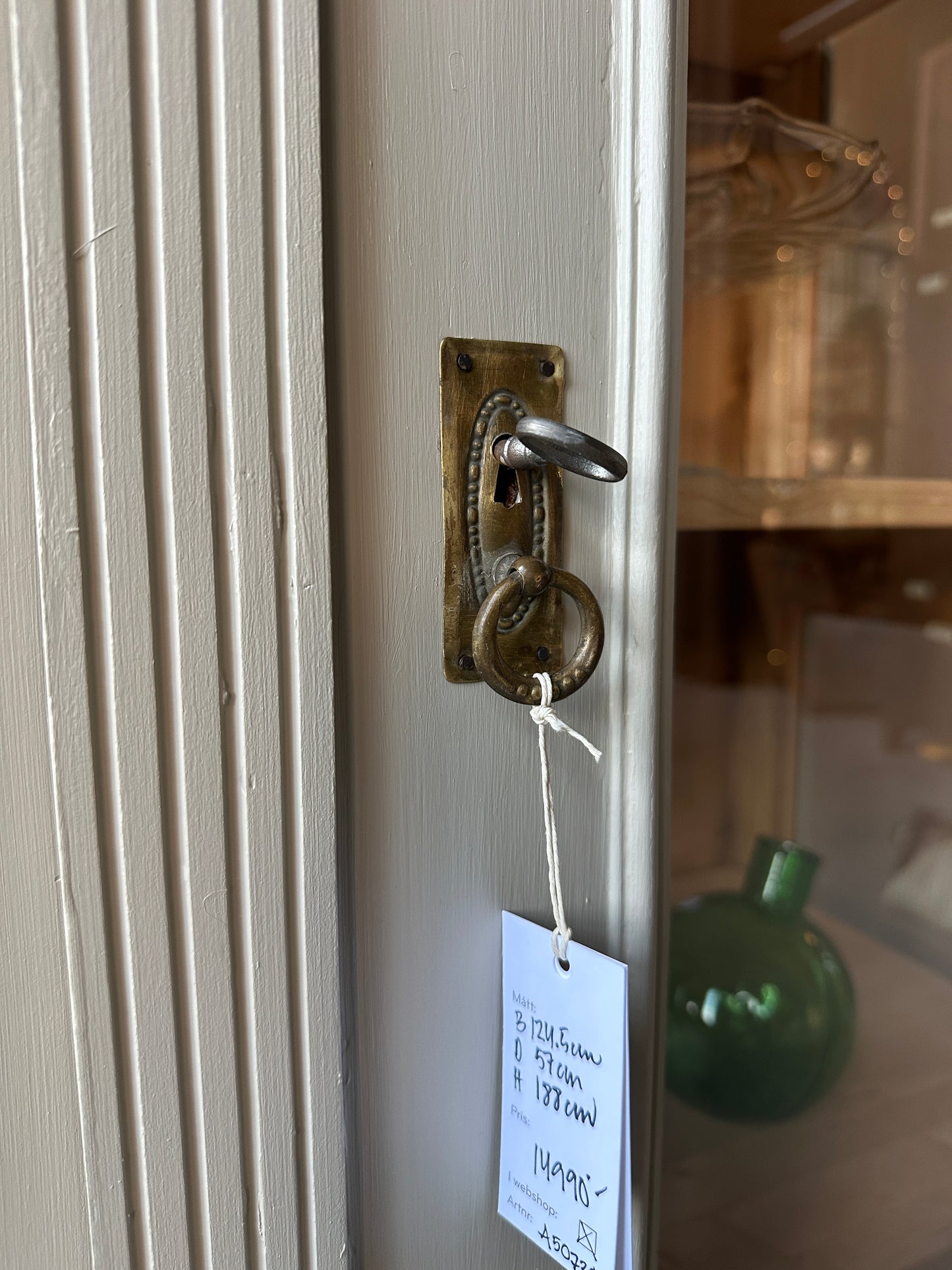 Ett gammalt vackert vitrinskåp med många vackra detaljer.
Skåpet har vitringlas även i sidorna för vackert ljusinsläpp. Längst ner finns en bred praktisk låda med porslinsknoppar.