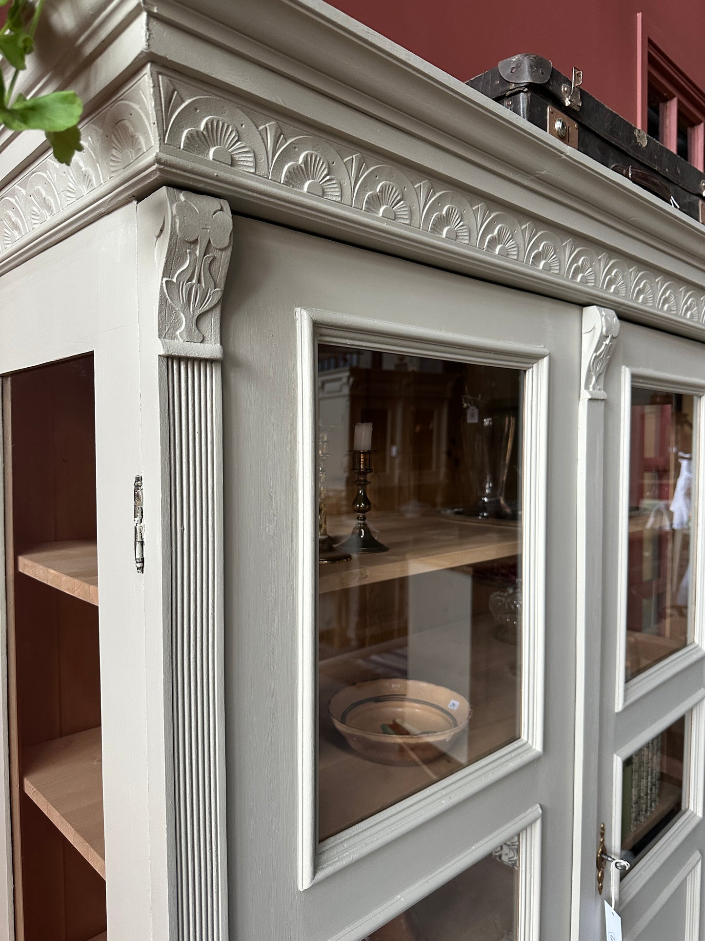 Ett gammalt vackert vitrinskåp med många vackra detaljer. Skåpet har glas i de fyra övre speglarna och täckt nertill för praktiskt dold förvaring