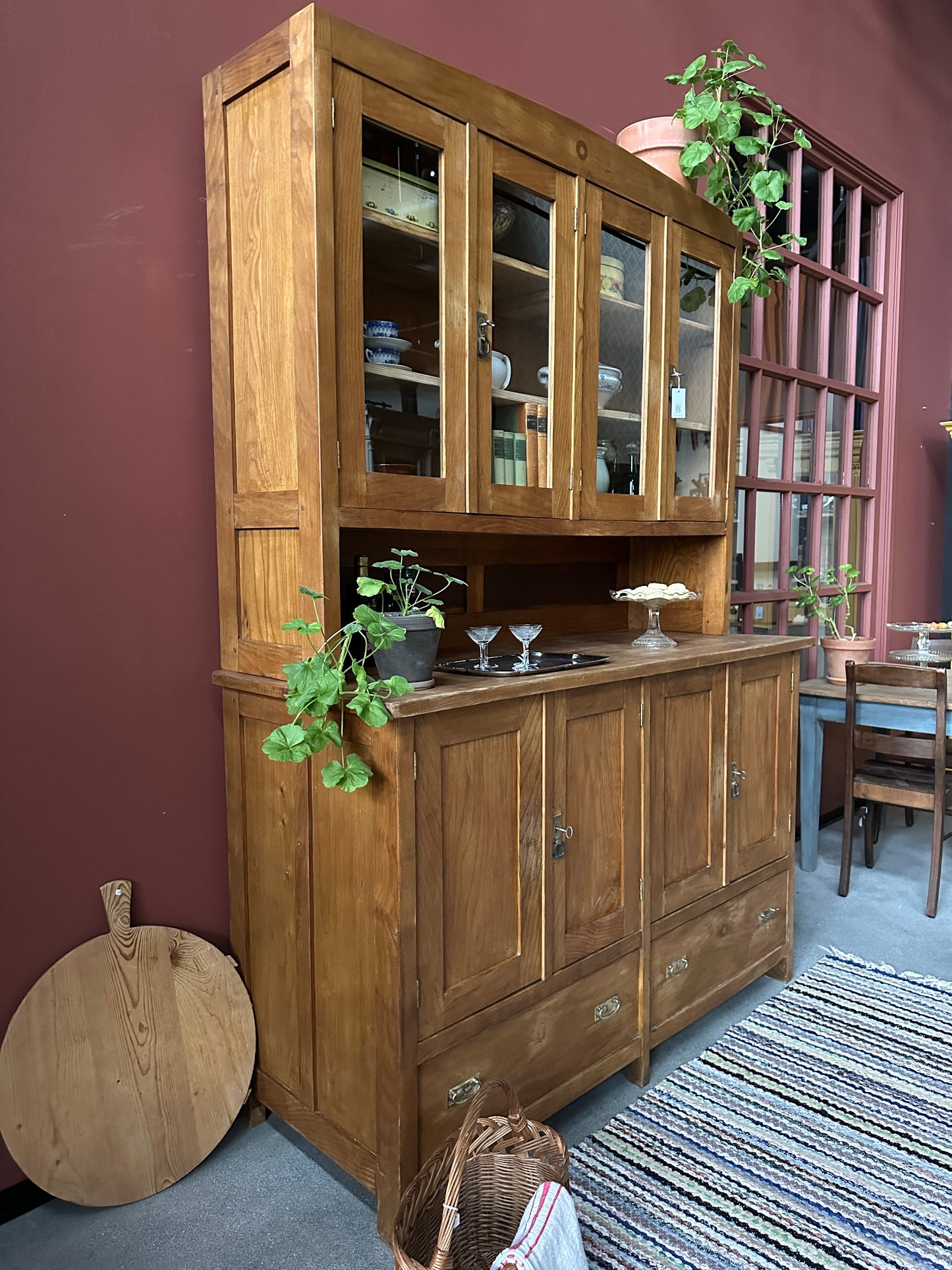 Ett gammalt vackert köksskåp med både dörrar i vitrin, en praktiskt avställningsyta, lådor samt täckta skåp