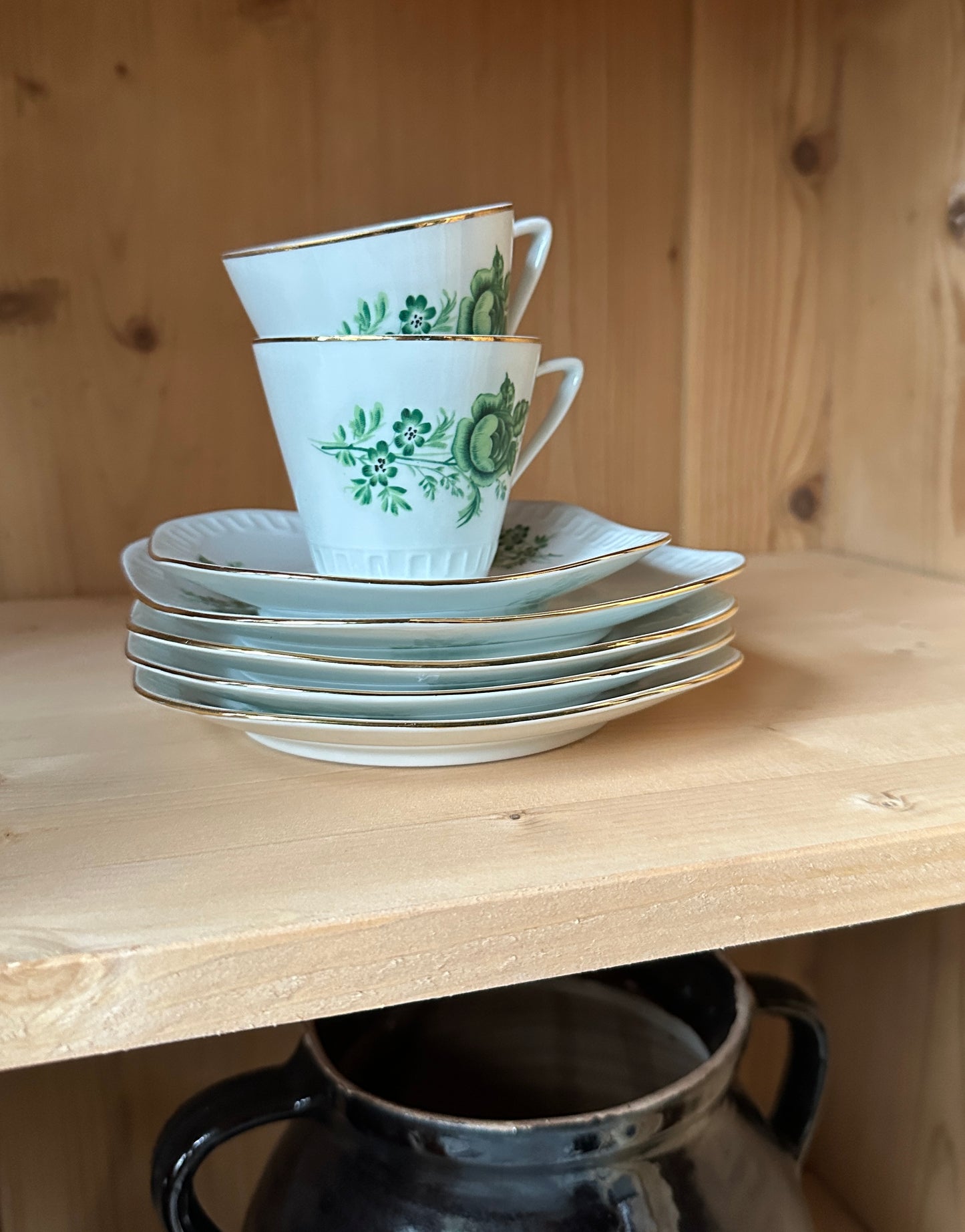 Ett gammalt, vackert vitrinskåp med fina detaljer i de rundade formerna och det arbetade krönet. Detaljbild hyllplan.