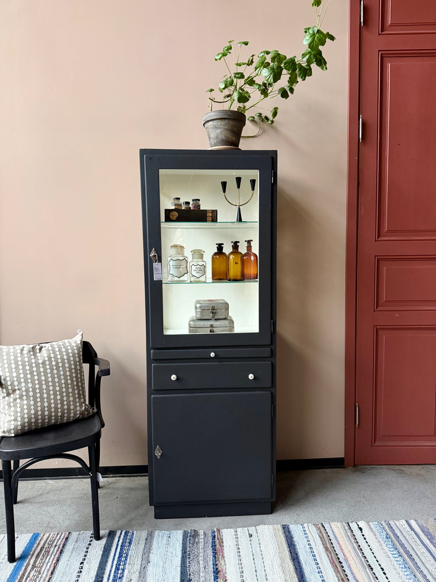 Ett gammalt läckert läkarskåp i trä med två hyllor i glas och även glas i sidan. Ett perfekt skåp för badrummet eller som vitrinskåp i köket .Skåpet har både en utdragbar skiva i trä samt låda och skåp med dold förvaring nertill och med fina porslinsknoppar. Väldigt praktiskt skåp helt enkelt.