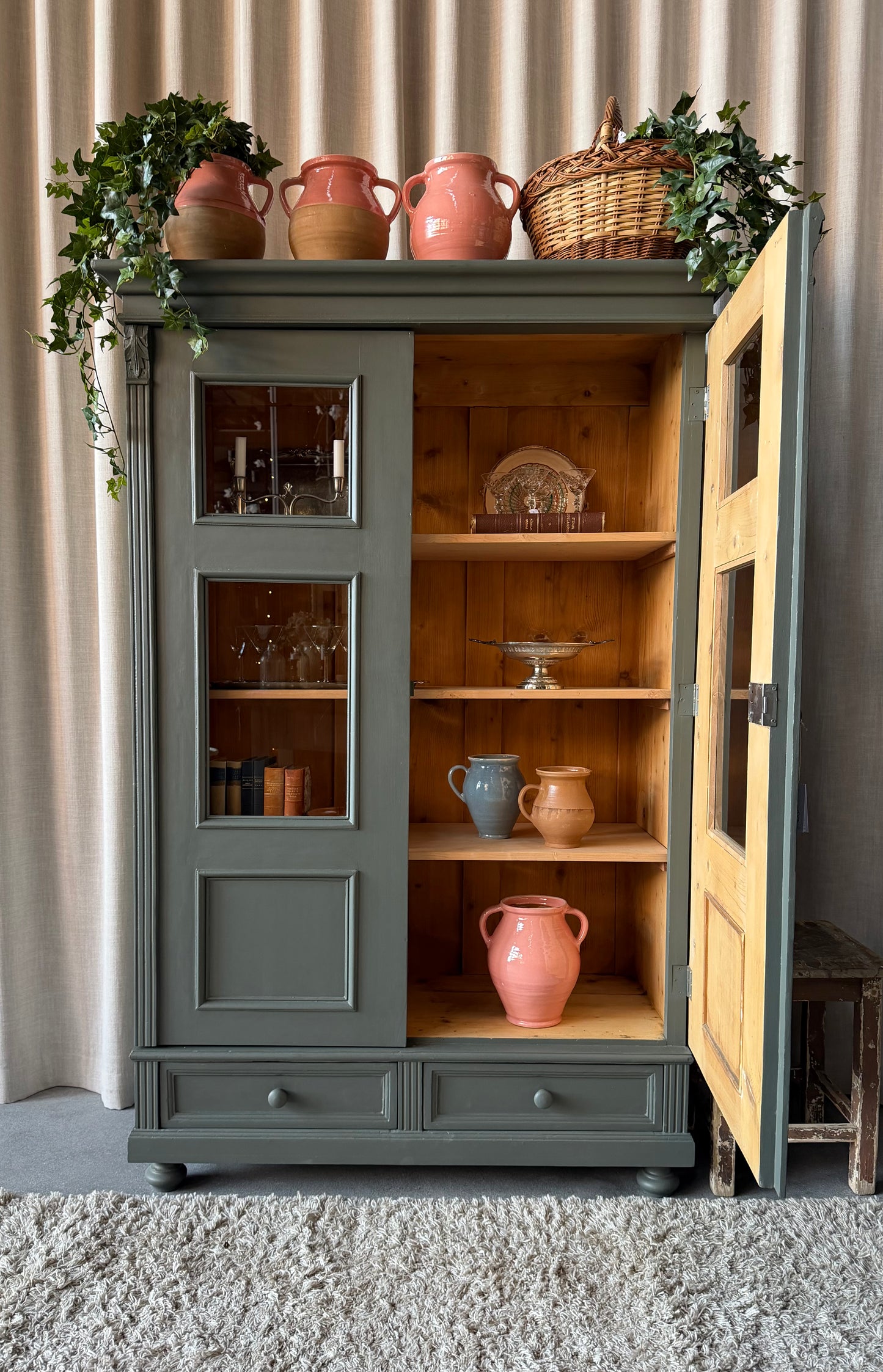 Ett vackert gammalt vitrinskåp med klassiska former och fina detaljer. Då skåpet har både vitringlas och dold förvaring blir denna möbel både vacker och praktisk.