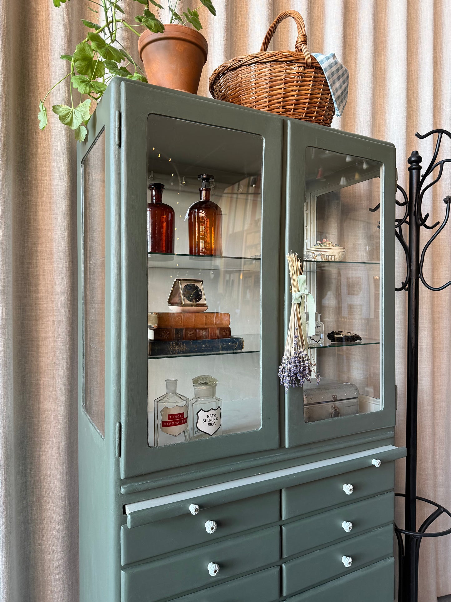 Ett gammalt läckert vitrinskåp/läkarskåp i trä med två hyllor i glas och även glas i sidan. Ett perfekt skåp för badrummet eller som vitrinskåp i kök eller vardagsrum. Skåpet har både en utdragbar skiva samt fina små lådor och skåp med dold förvaring nertill. Ett väldigt praktiskt skåp helt enkelt. Skåpet har fina tidstypiska porslinsknoppar och beslag.