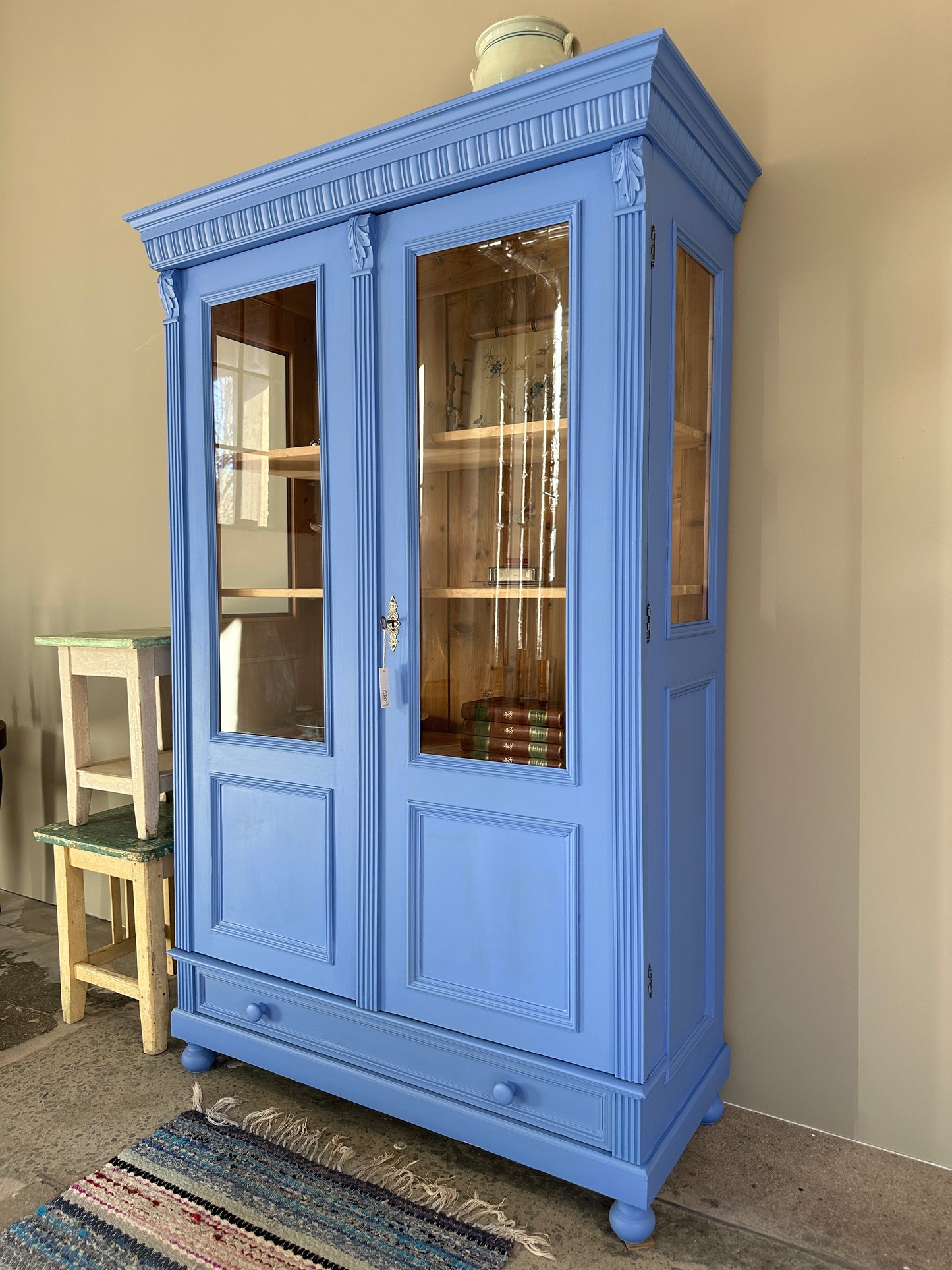 Bild visar blått vitrinskåp med två dörrar. Bild tagen från sidan