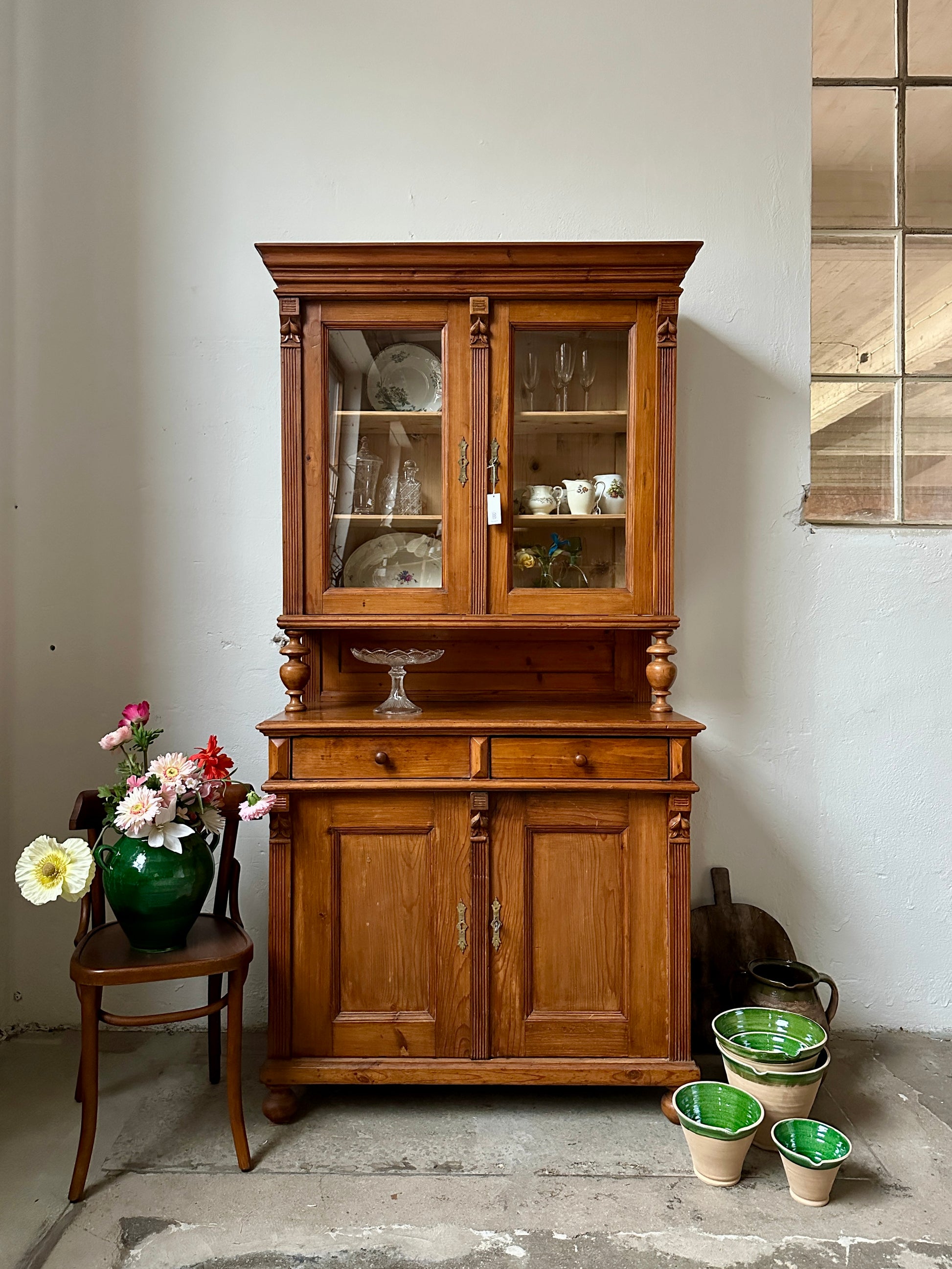 Ett gammalt, vackert köksskåp med symmetrisk utformning och mängder av förvaringsmöjligheter