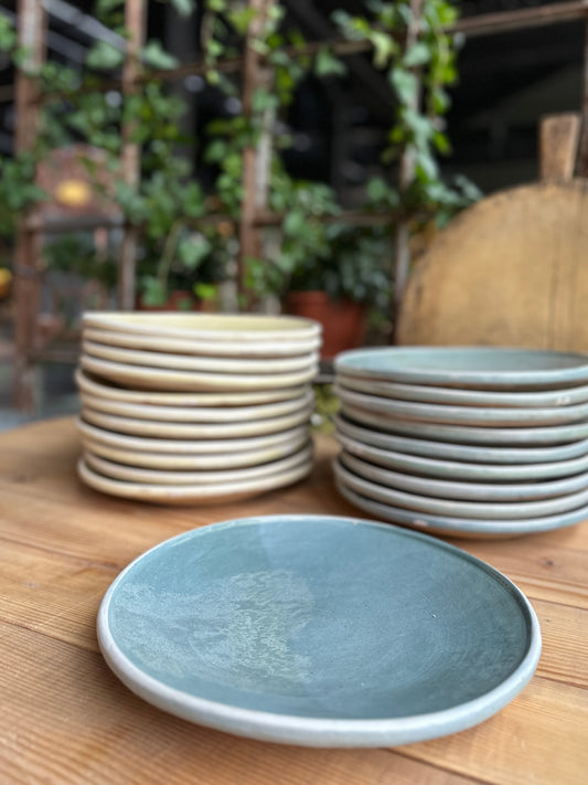 Staplade tallrikar i cremevitt och blågrått.