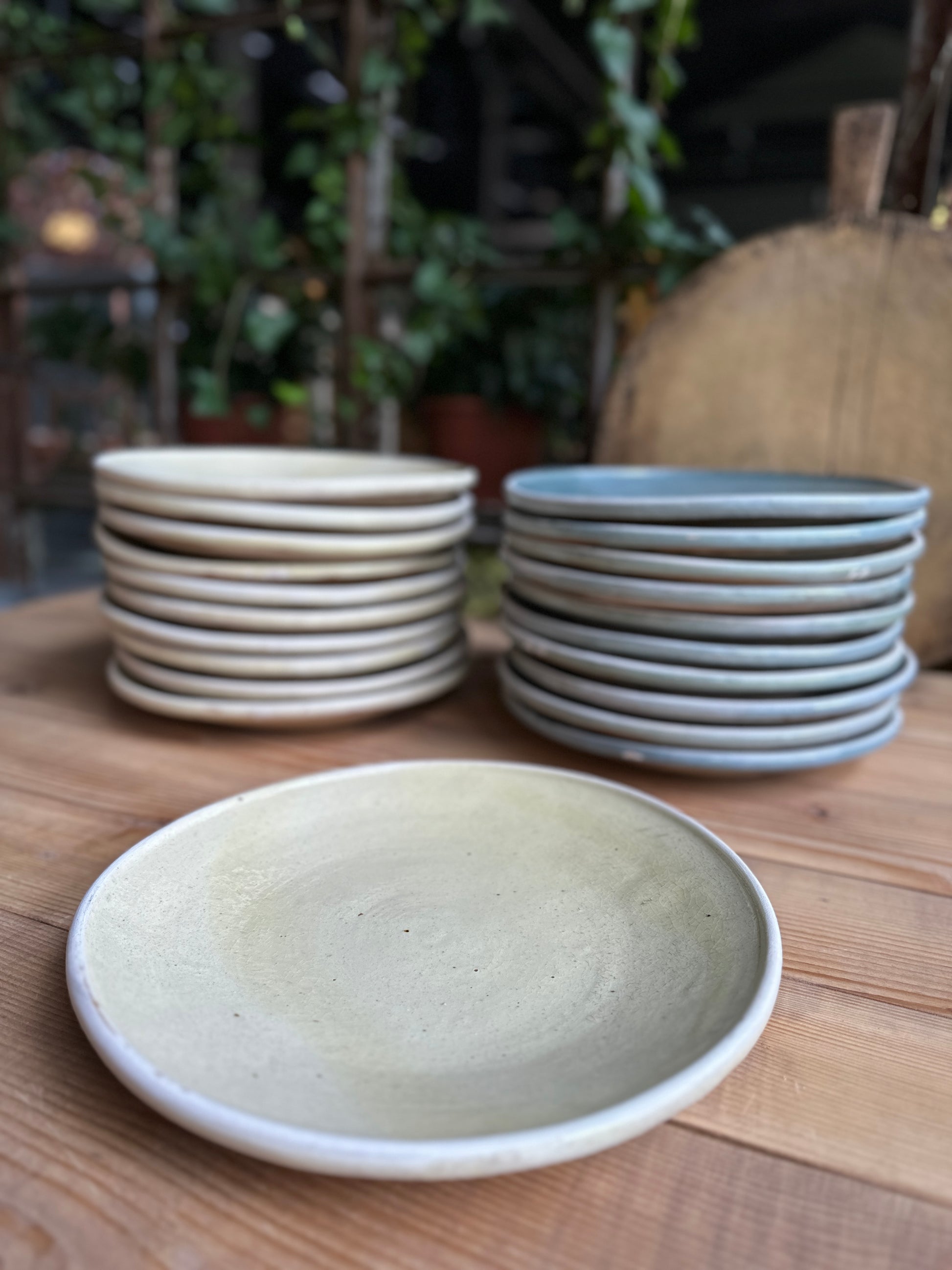 Staplade tallrikar i cremevitt och blågrått.