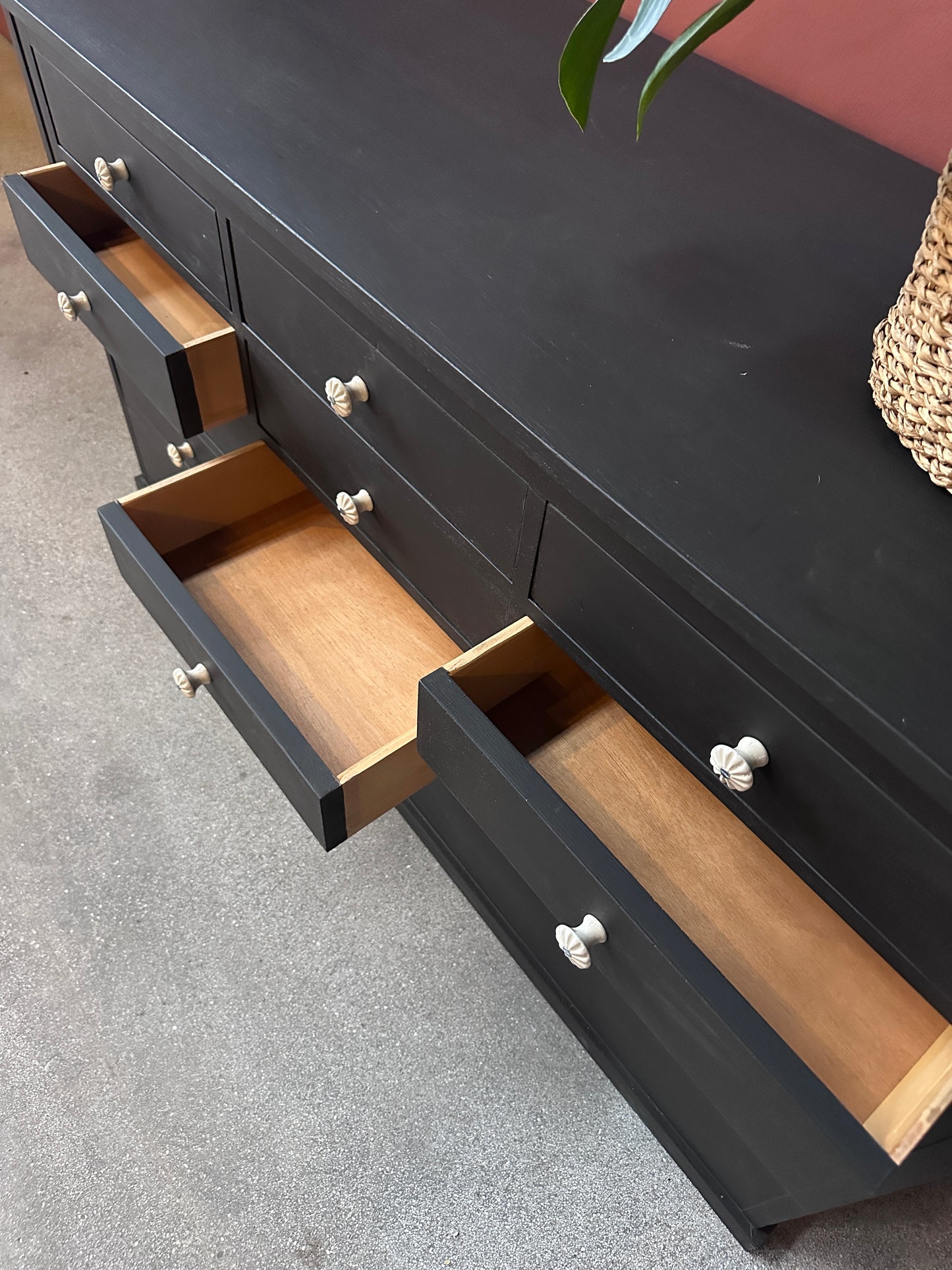 Detaljbild på utdragna lådor i en svart kommod.
