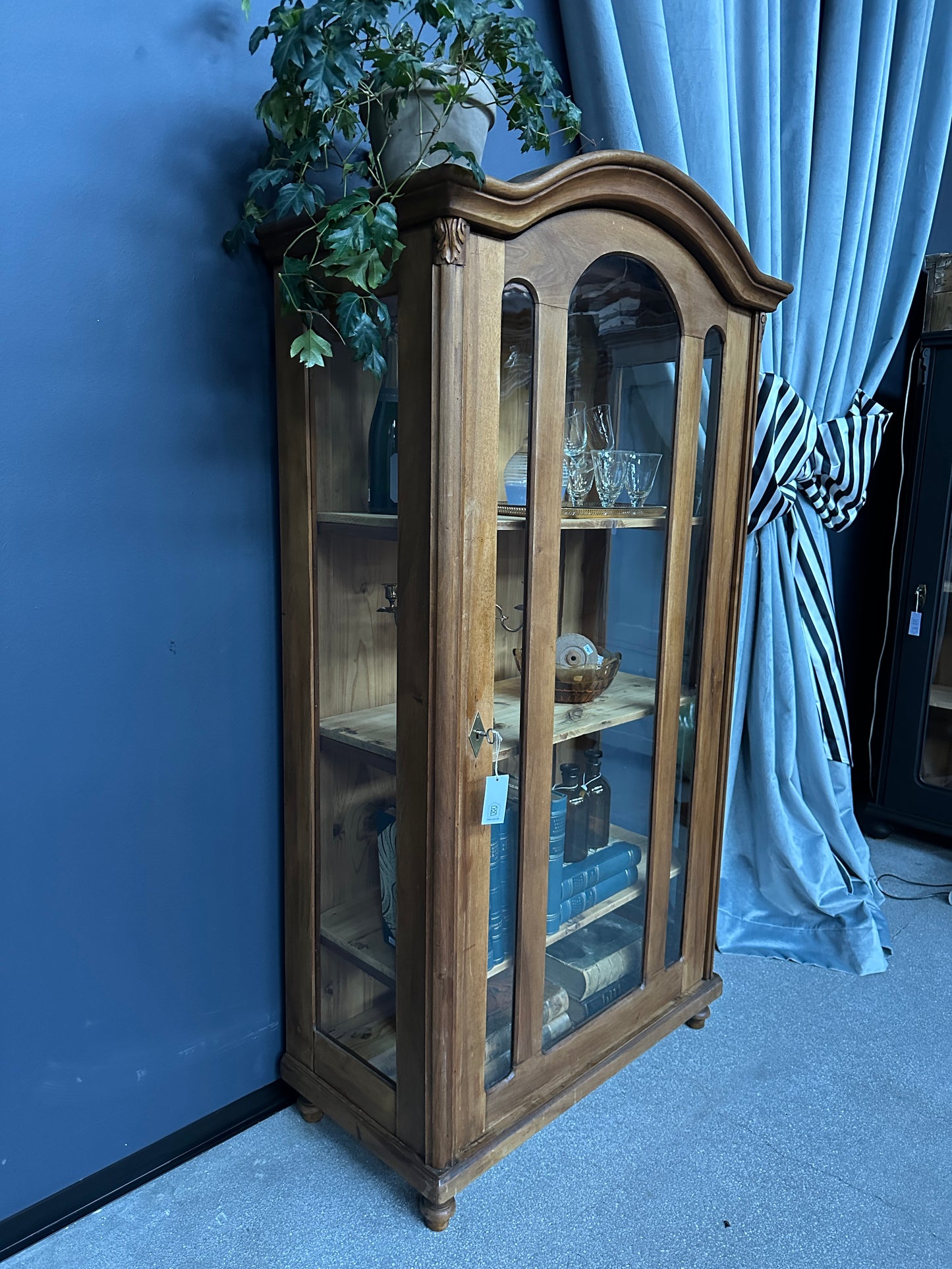 brunt vitrinskåp mot blå vägg