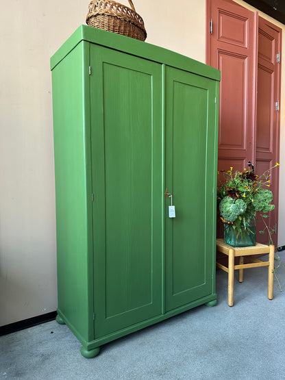 Ett gammalt vackert grönt linneskåp med raka former och färre detaljer