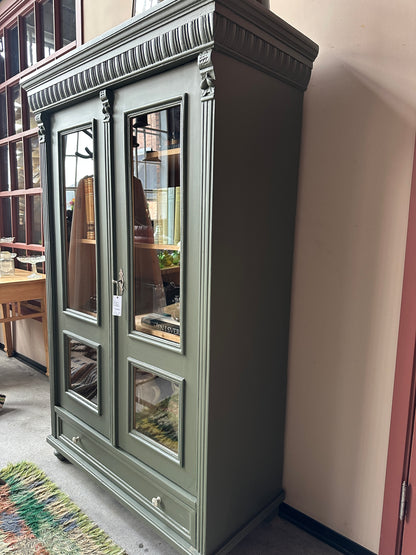 Ett gammalt vackert vitrinskåp med vackra detaljer. Skåpet har en bred praktiskt låda nertill med nya porslinsknoppar i äldre stil.