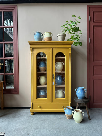 Ett gammalt, vackert vitrinskåp med fina detaljer i de rundade formerna och det arbetade krönet. Skåpet är endast 40 cm djupt mätt uppe på krönet!