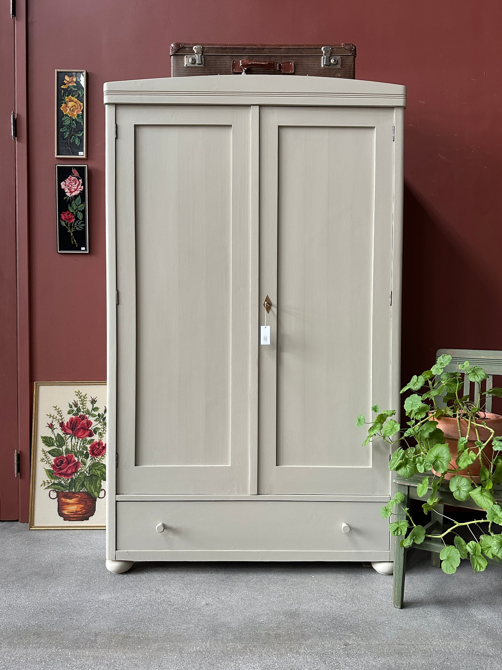 Ett gammalt vackert linneskåp med raka former och färre detaljer. Det har en praktisk låda längst ner med inmålade knoppar i trä