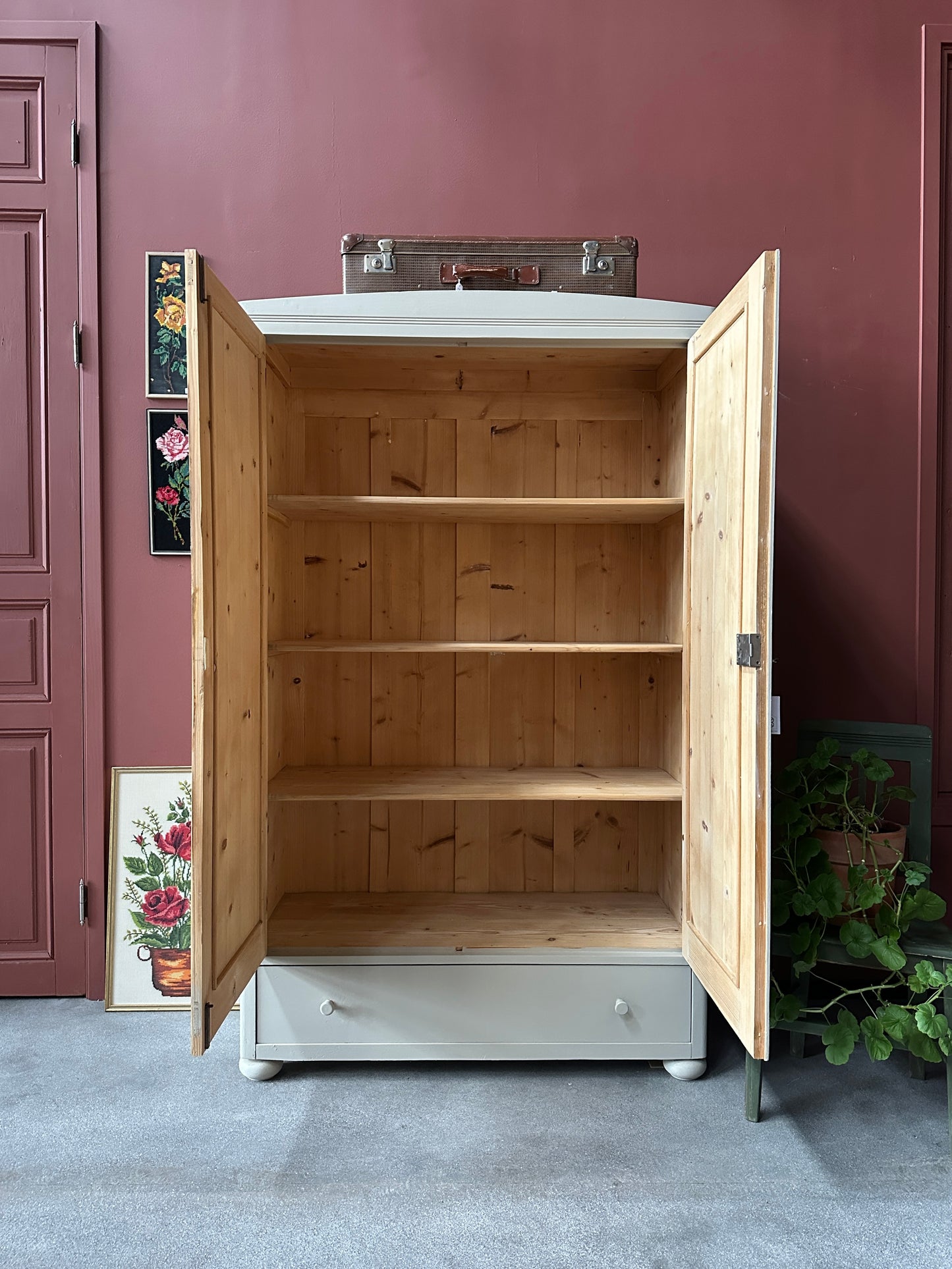 Ett gammalt vackert linneskåp med raka former och färre detaljer. Det har en praktisk låda längst ner med inmålade knoppar i trä