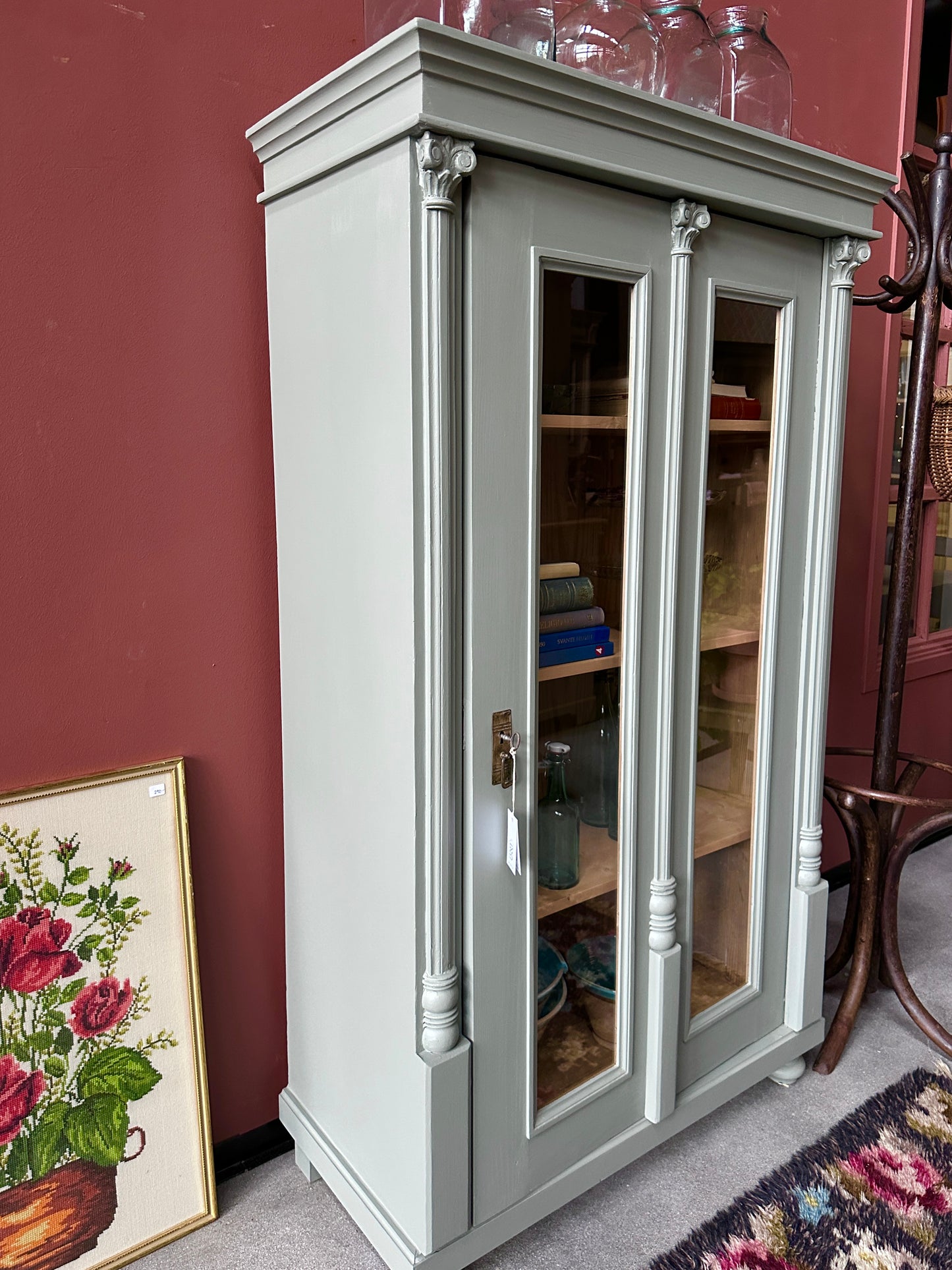 Ett fint gammalt vitrinskåp med vackra detaljer. Skåpet har en högerhängd dörr med glas hela vägen ner i 2 speglar