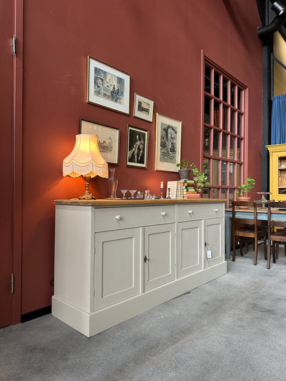 En vacker skänk med förvaring i form av både lådor och skåp.
Skänken är penselmålad med en matt snickerifärg i en Dakaboms greiga kulör