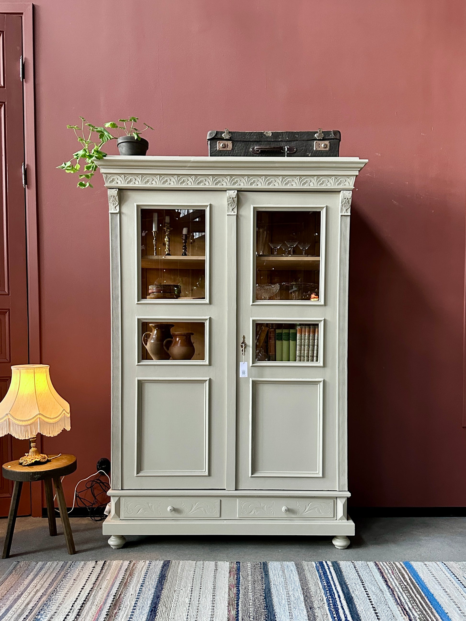 Ett gammalt vackert vitrinskåp med många vackra detaljer. Skåpet har glas i de fyra övre speglarna och täckt nertill för praktiskt dold förvaring