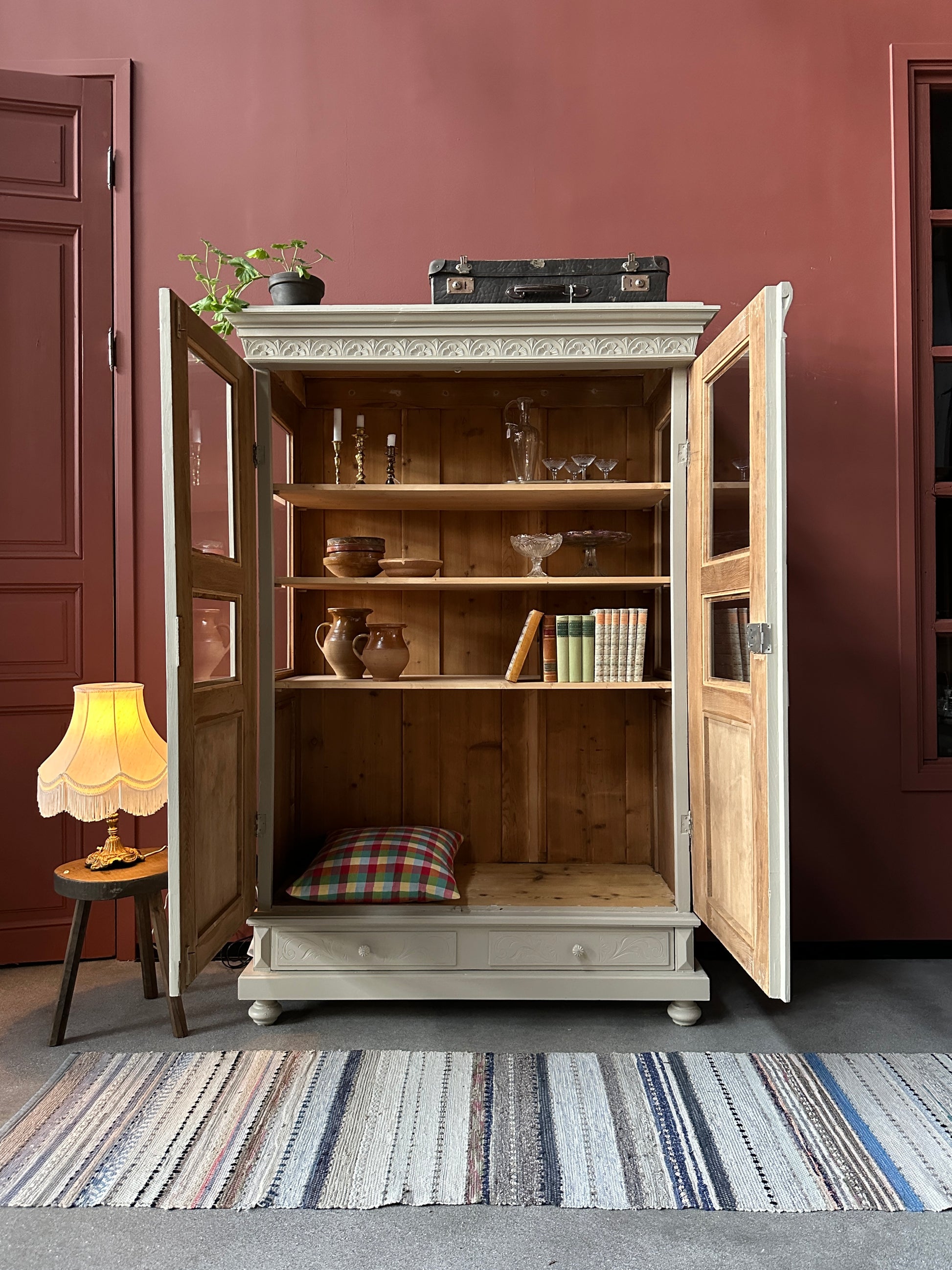 Ett gammalt vackert vitrinskåp med många vackra detaljer. Skåpet har glas i de fyra övre speglarna och täckt nertill för praktiskt dold förvaring