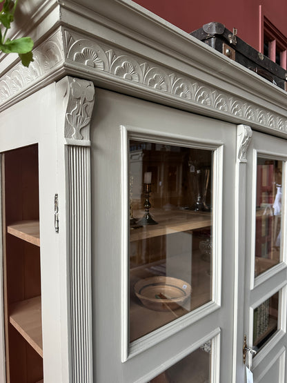 Ett gammalt vackert vitrinskåp med många vackra detaljer. Skåpet har glas i de fyra övre speglarna och täckt nertill för praktiskt dold förvaring