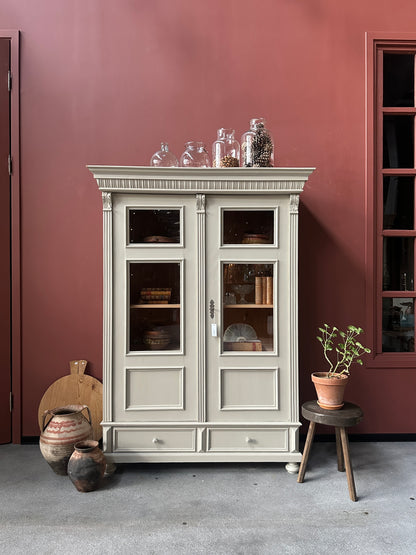 Ett gammalt vackert vitrinskåp med många vackra detaljer. Skåpet har glas i de fyra övre speglarna och täckt nertill för praktiskt dold förvaring