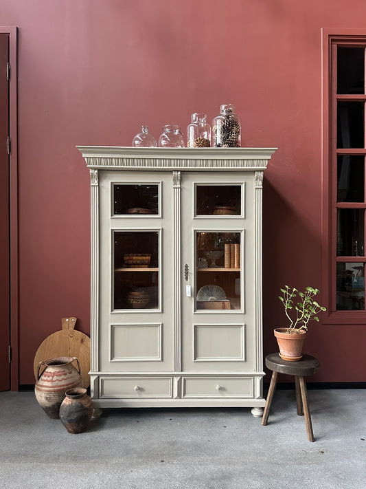 Ett gammalt vackert vitrinskåp med många vackra detaljer. Skåpet har glas i de fyra övre speglarna och täckt nertill för praktiskt dold förvaring
