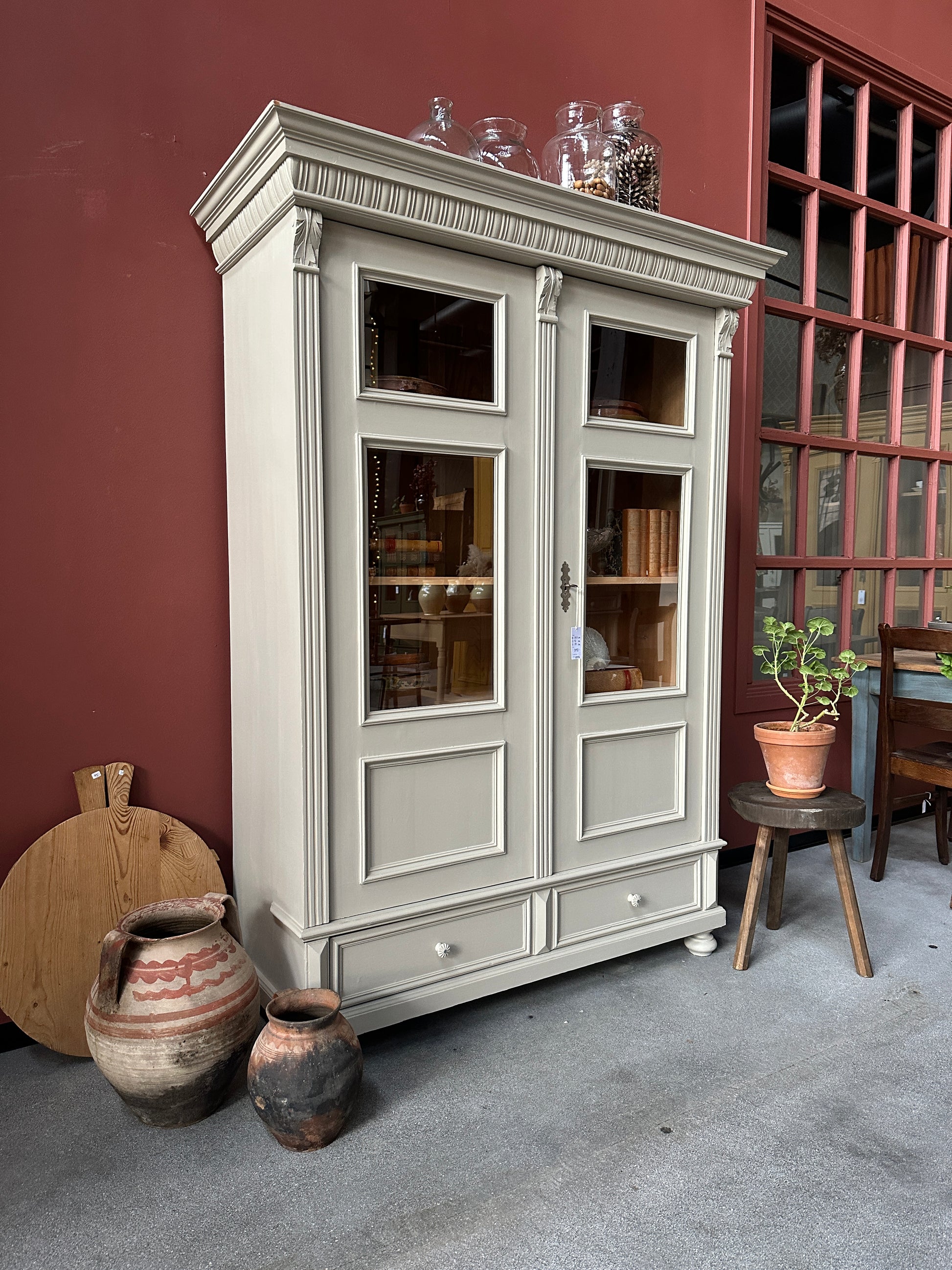 Ett gammalt vackert vitrinskåp med många vackra detaljer. Skåpet har glas i de fyra övre speglarna och täckt nertill för praktiskt dold förvaring