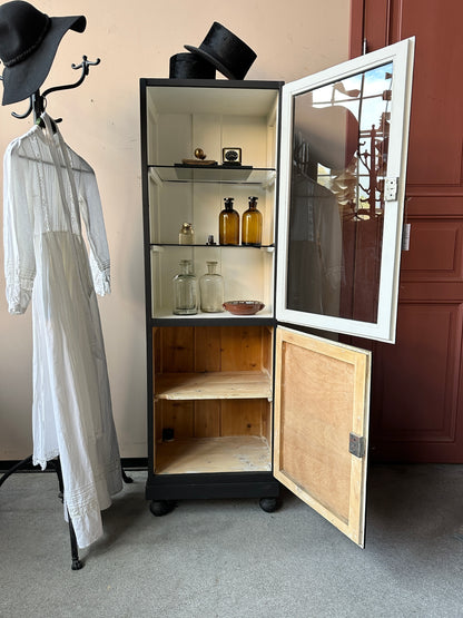 Ett gammalt klassiskt läkarskåp med två hyllor i glas.&nbsp;
Skåpet har både dörr med glas samt täckt dörr nertill.