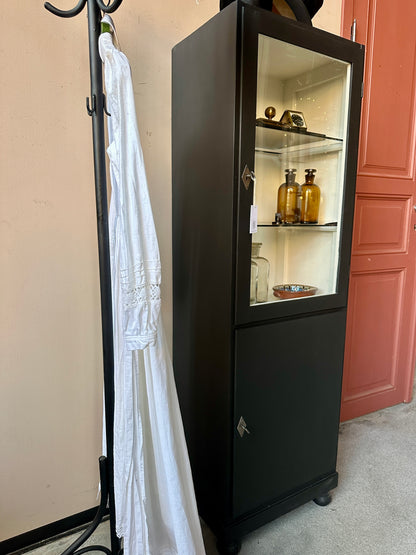 Ett gammalt klassiskt läkarskåp med två hyllor i glas.&nbsp;
Skåpet har både dörr med glas samt täckt dörr nertill.