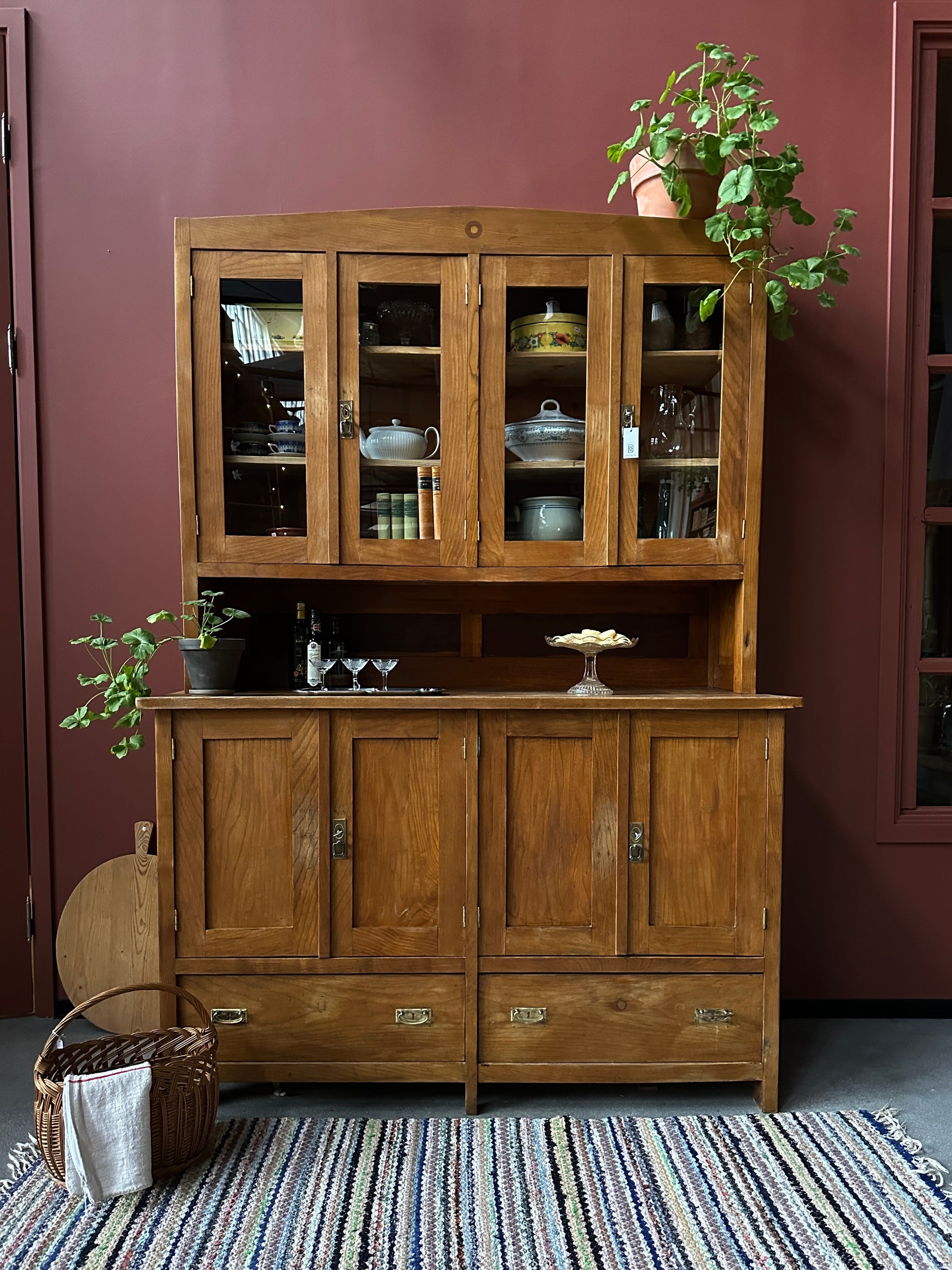 Ett gammalt vackert köksskåp med både dörrar i vitrin, en praktiskt avställningsyta, lådor samt täckta skåp