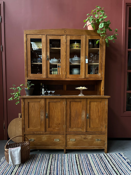 Ett gammalt vackert köksskåp med både dörrar i vitrin, en praktiskt avställningsyta, lådor samt täckta skåp