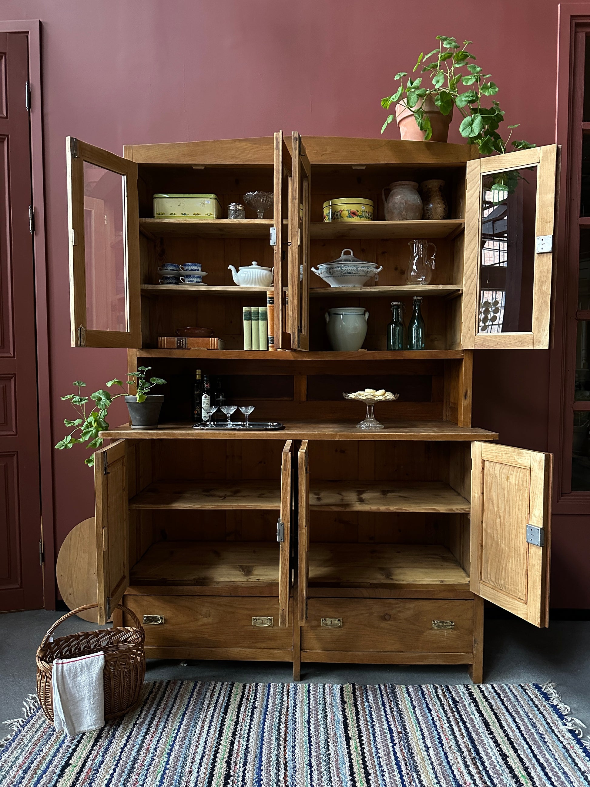 Ett gammalt vackert köksskåp med både dörrar i vitrin, en praktiskt avställningsyta, lådor samt täckta skåp