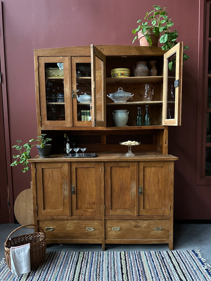 Ett gammalt vackert köksskåp med både dörrar i vitrin, en praktiskt avställningsyta, lådor samt täckta skåp