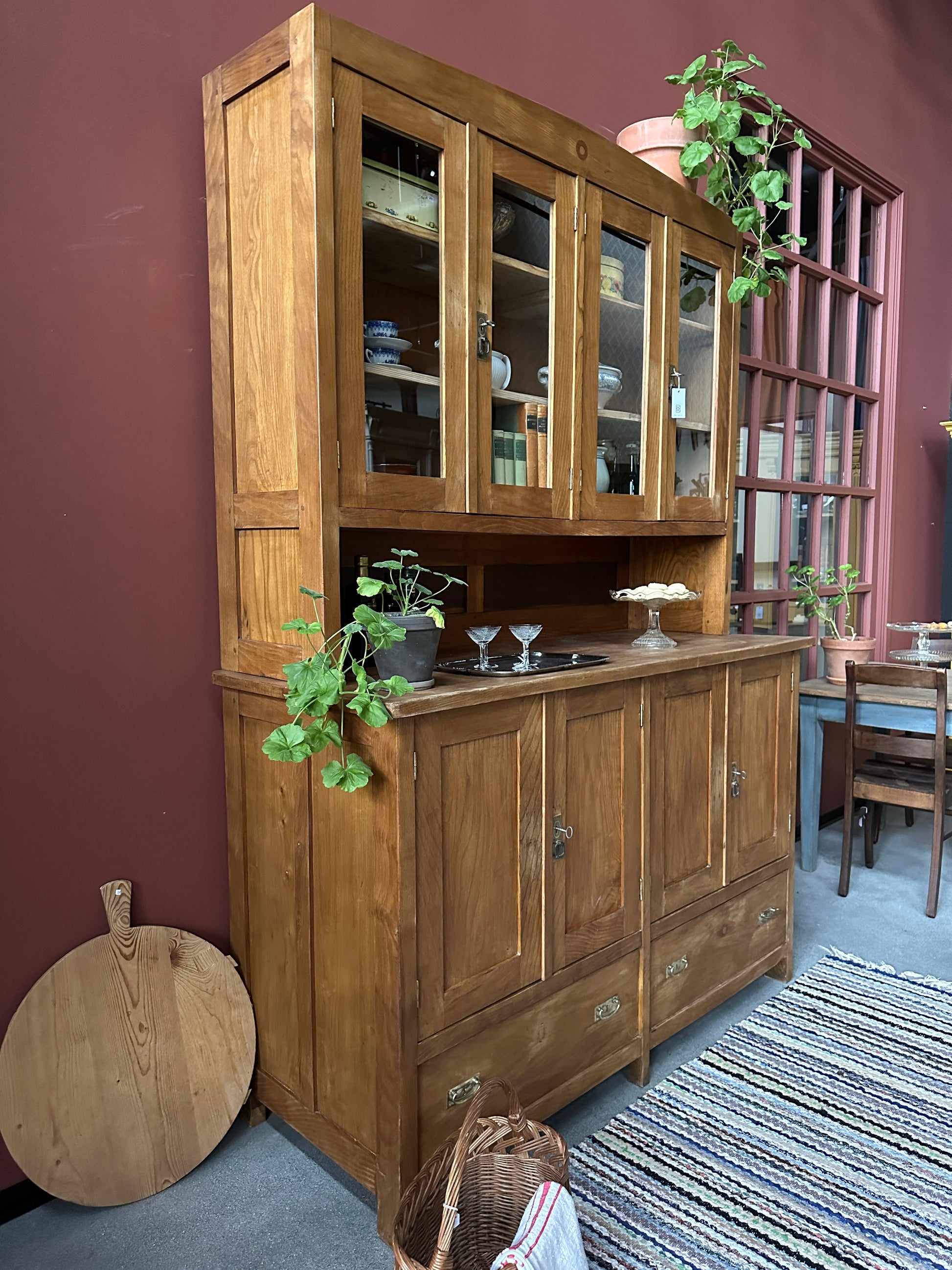 Ett gammalt vackert köksskåp med både dörrar i vitrin, en praktiskt avställningsyta, lådor samt täckta skåp