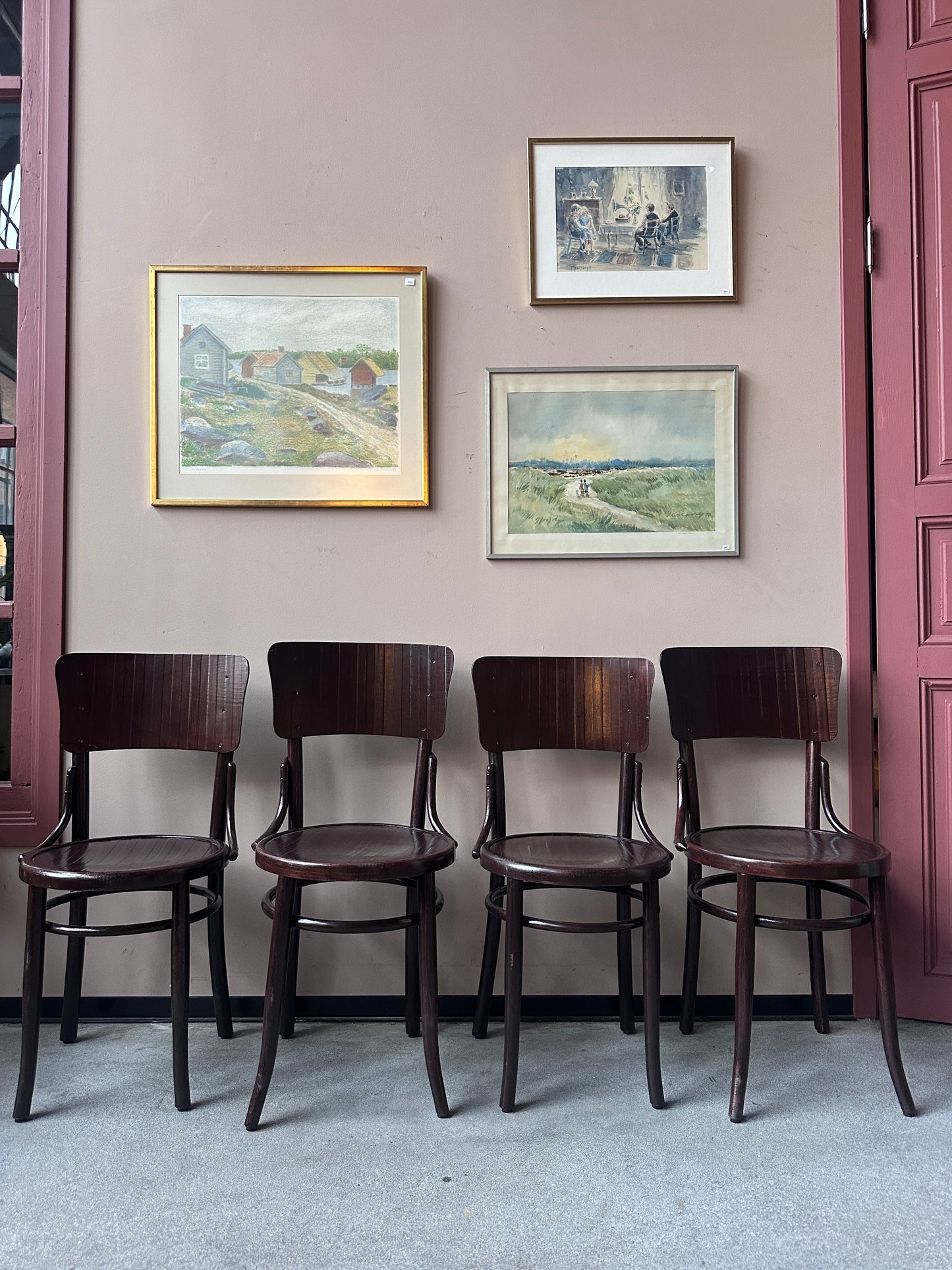 4 st stolar mot en vägg med 3 st tavlor. 