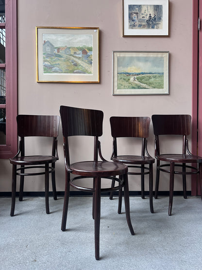 4 st stolar mot en vägg med 3 st tavlor. 