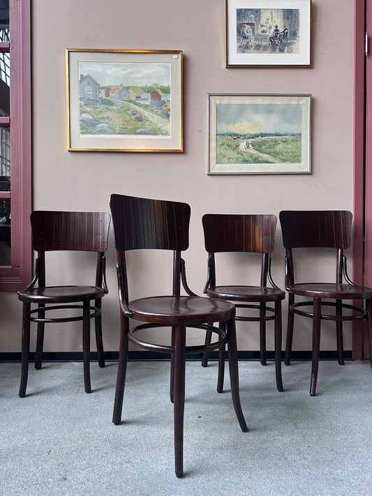 4 st stolar mot en vägg med 3 st tavlor. 