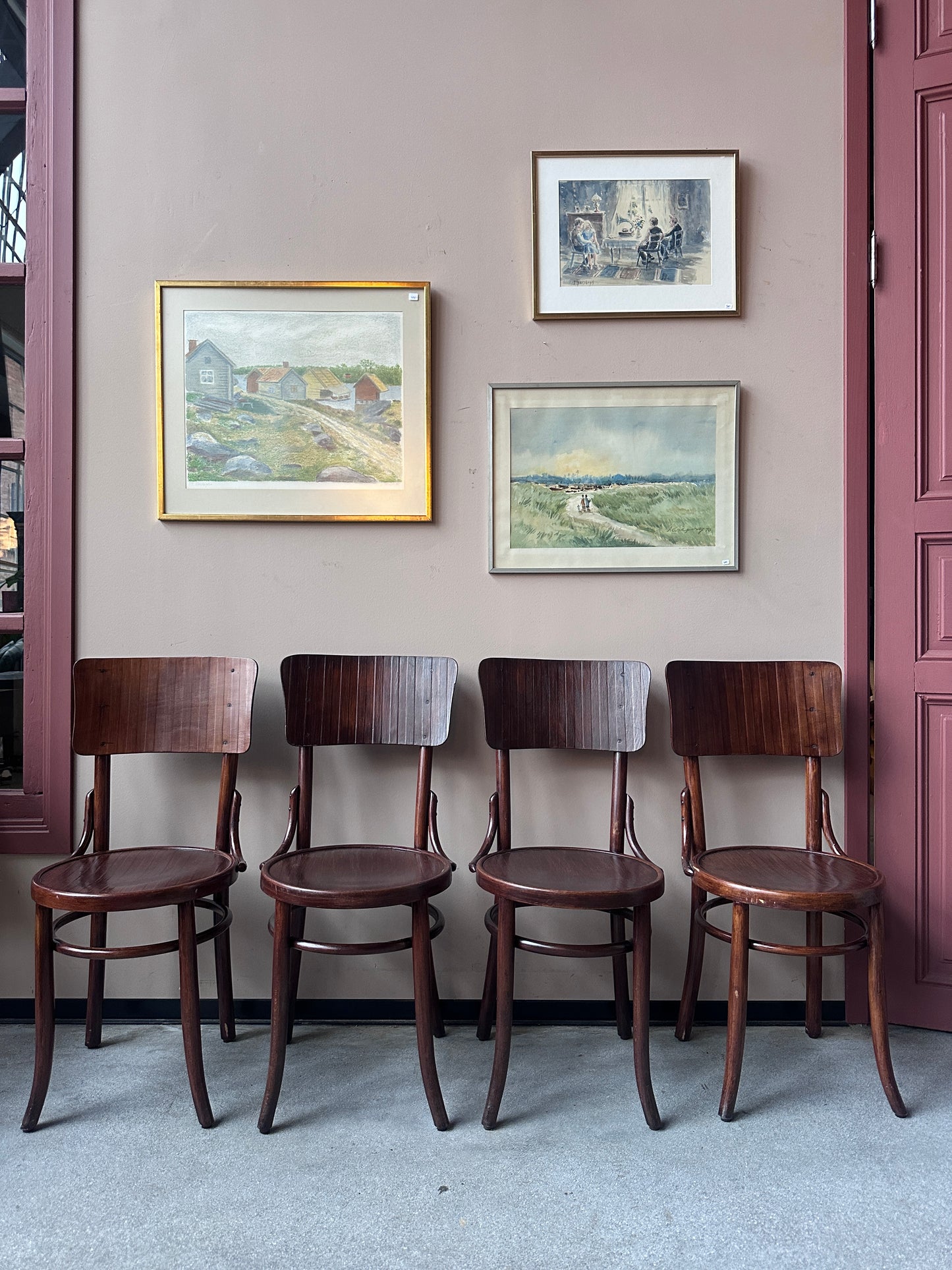 4 st stolar mot en vägg med 3 st tavlor. 