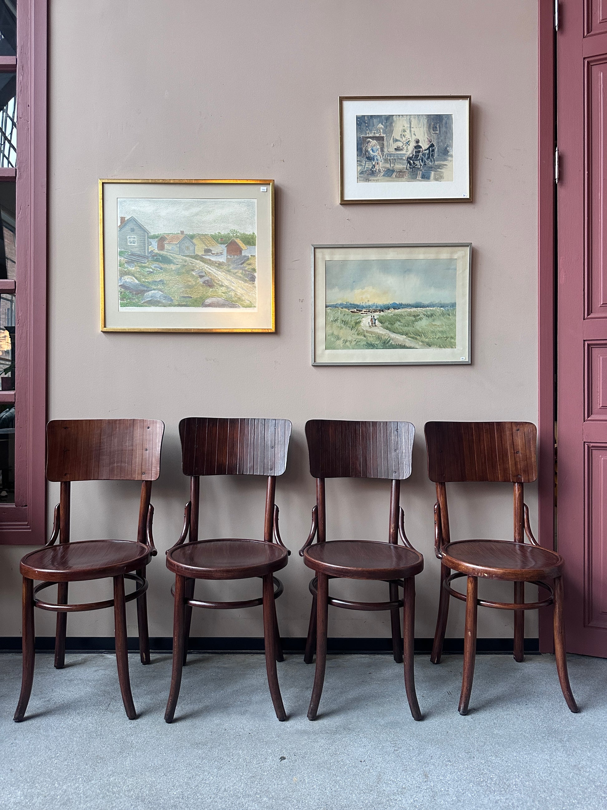 4 st stolar mot en vägg med 3 st tavlor. 