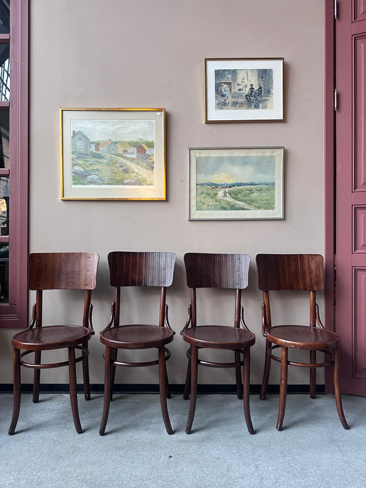 4 st stolar mot en vägg med 3 st tavlor. 