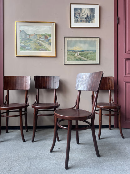 4 st stolar mot en vägg med 3 st tavlor. 