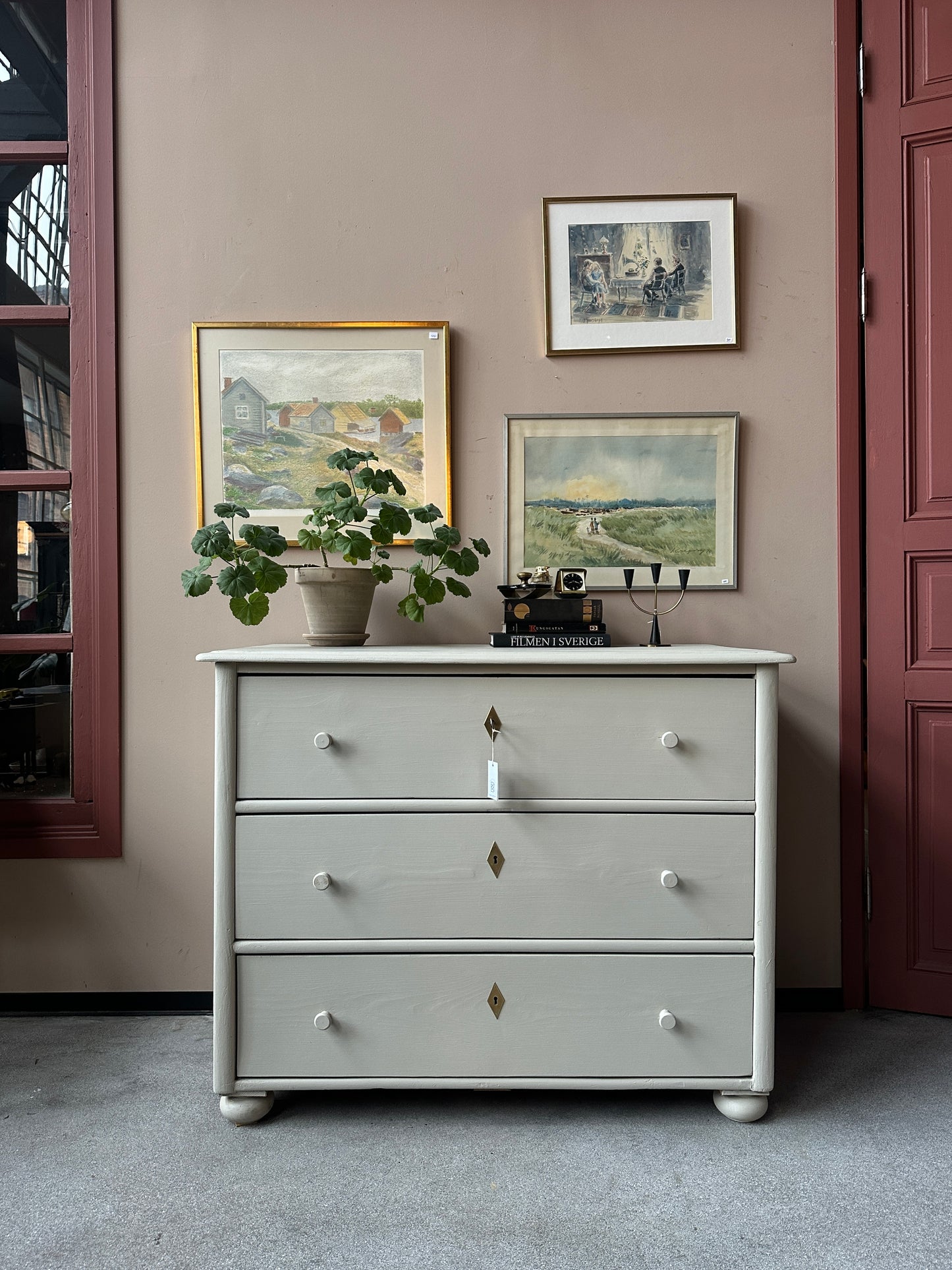 En gammal, vacker byrå i större mått med massor av förvaring. Den har 3 st praktiska lådor med inmålade träknoppar.