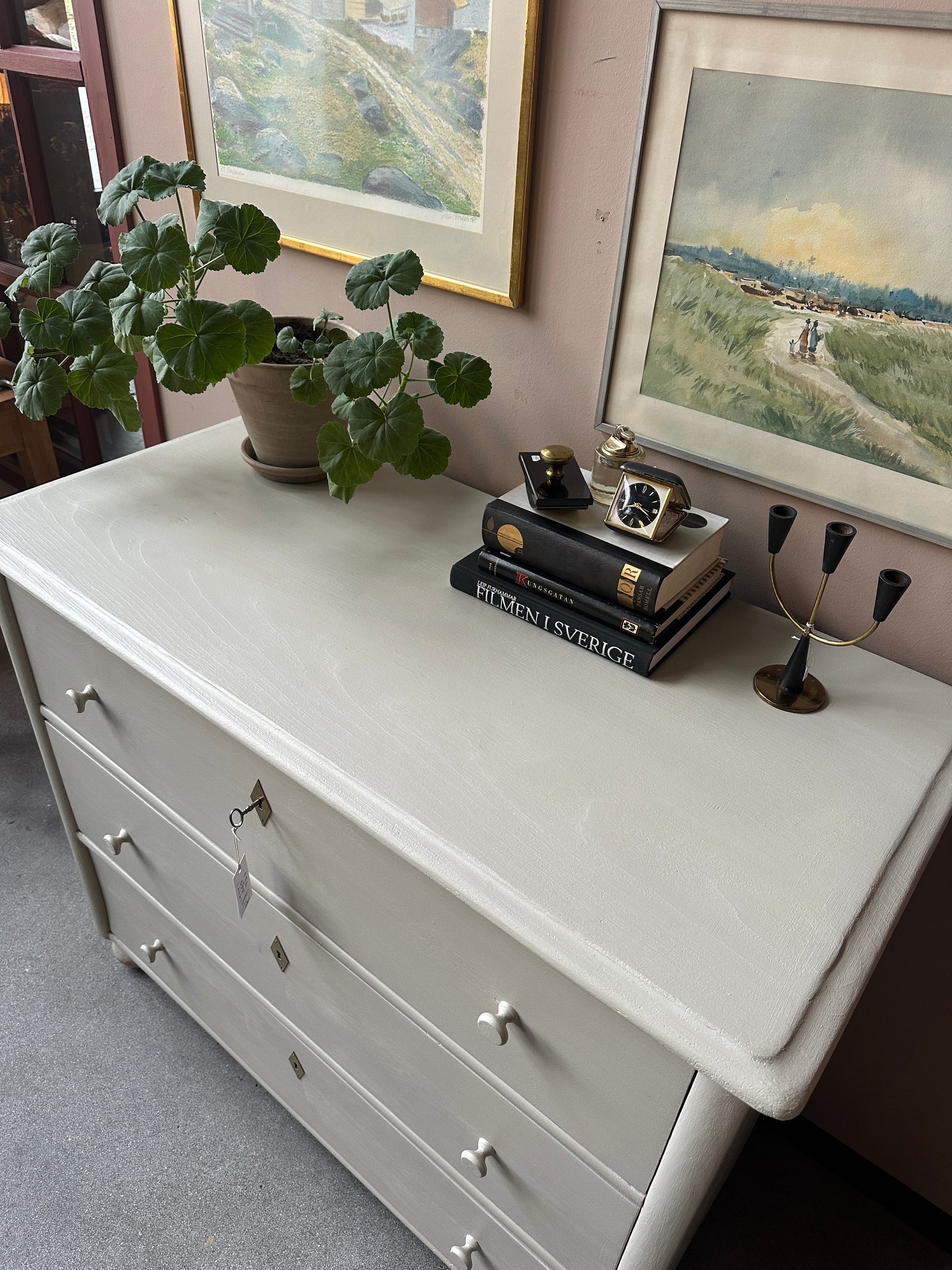 En gammal, vacker byrå i större mått med massor av förvaring. Den har 3 st praktiska lådor med inmålade träknoppar.