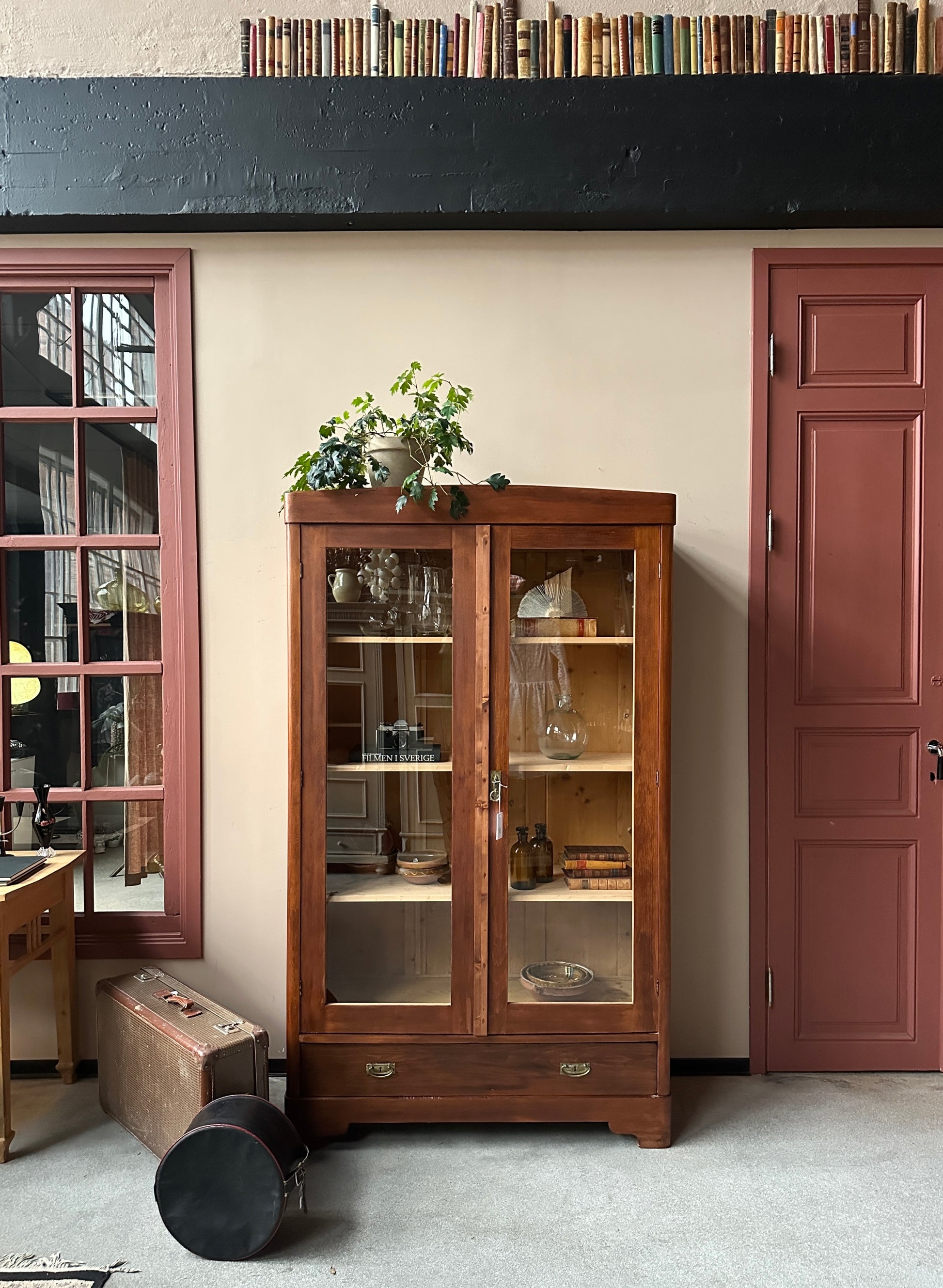 Ett gammalt vackert vitrinskåp med raka och enkla linjer.