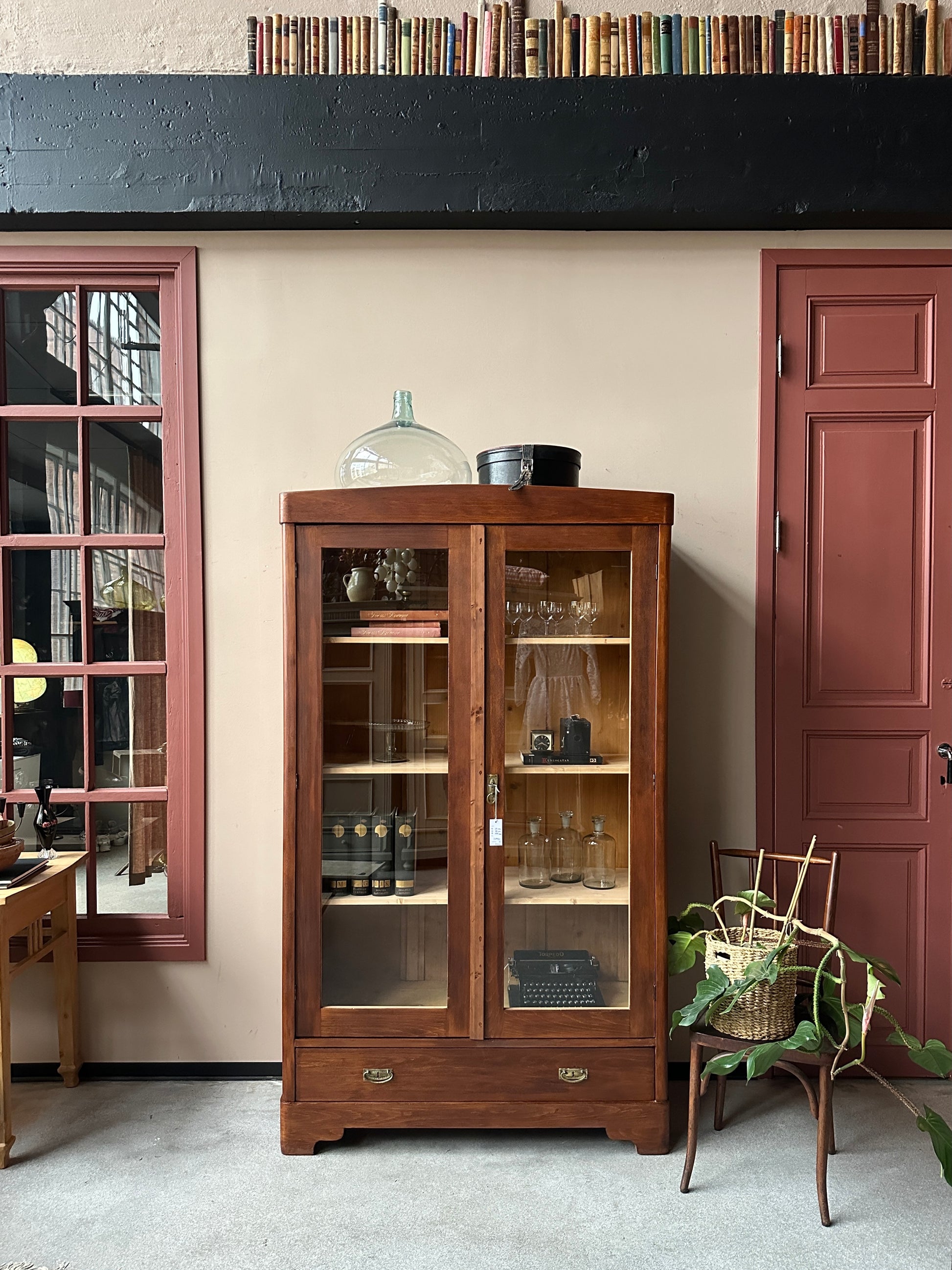 Ett gammalt vackert vitrinskåp med raka och enkla linjer.