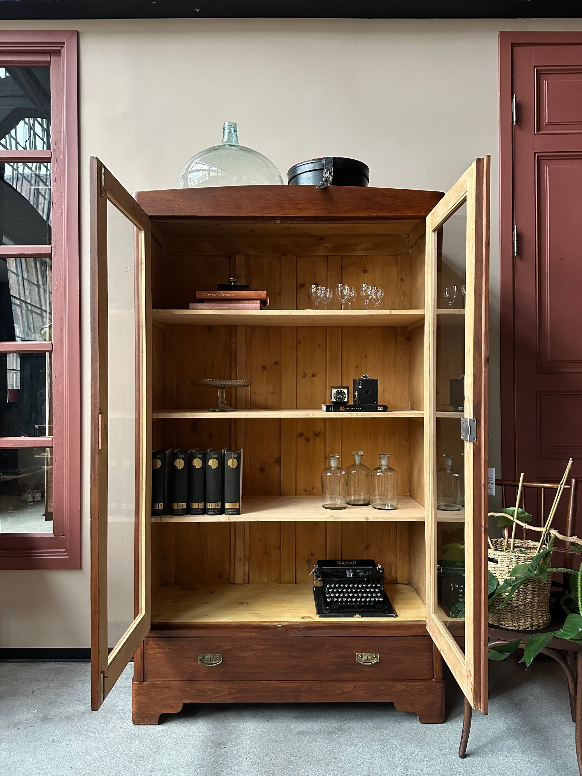 Ett gammalt vackert vitrinskåp med raka och enkla linjer.