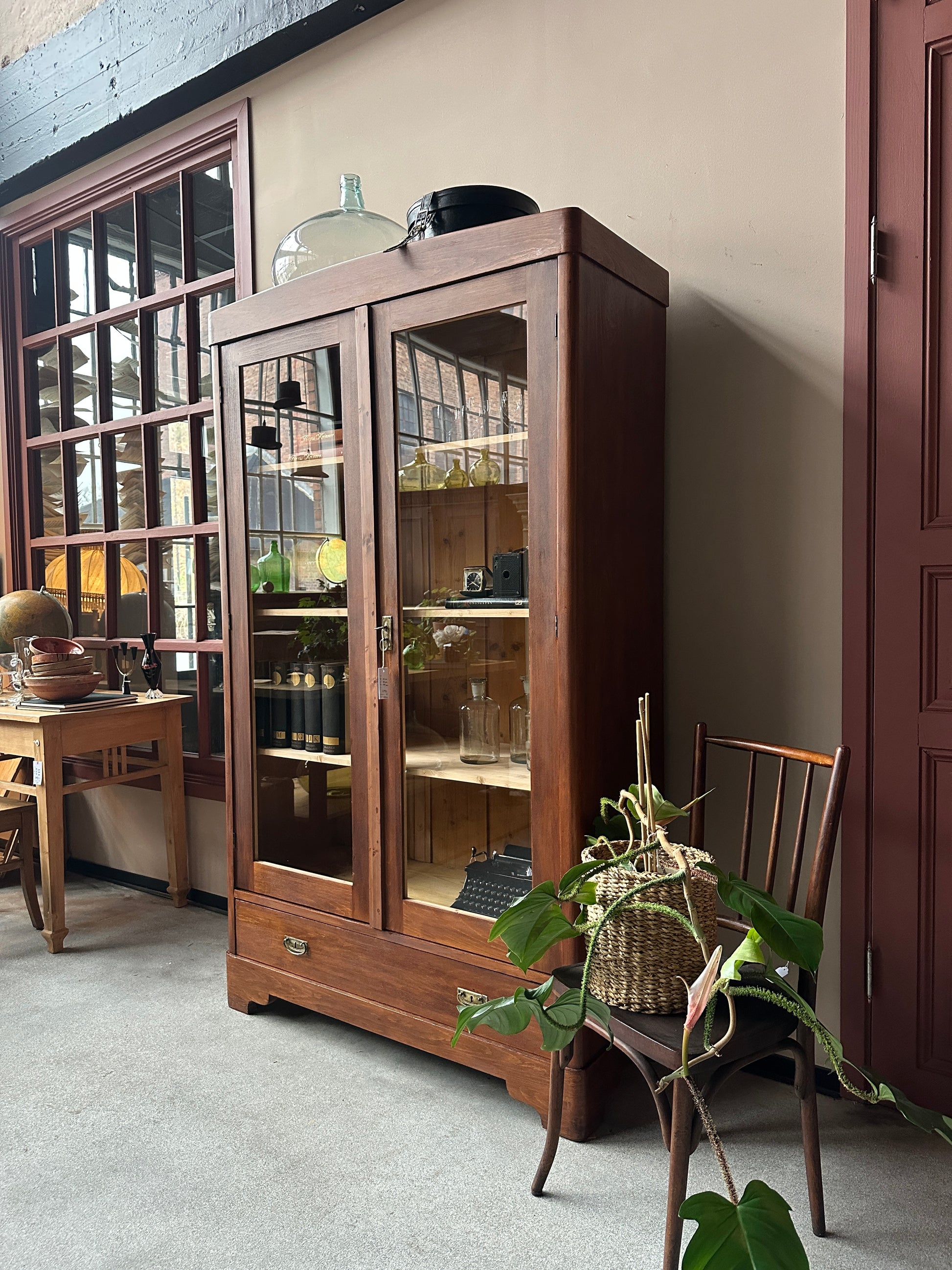 Ett gammalt vackert vitrinskåp med raka och enkla linjer.