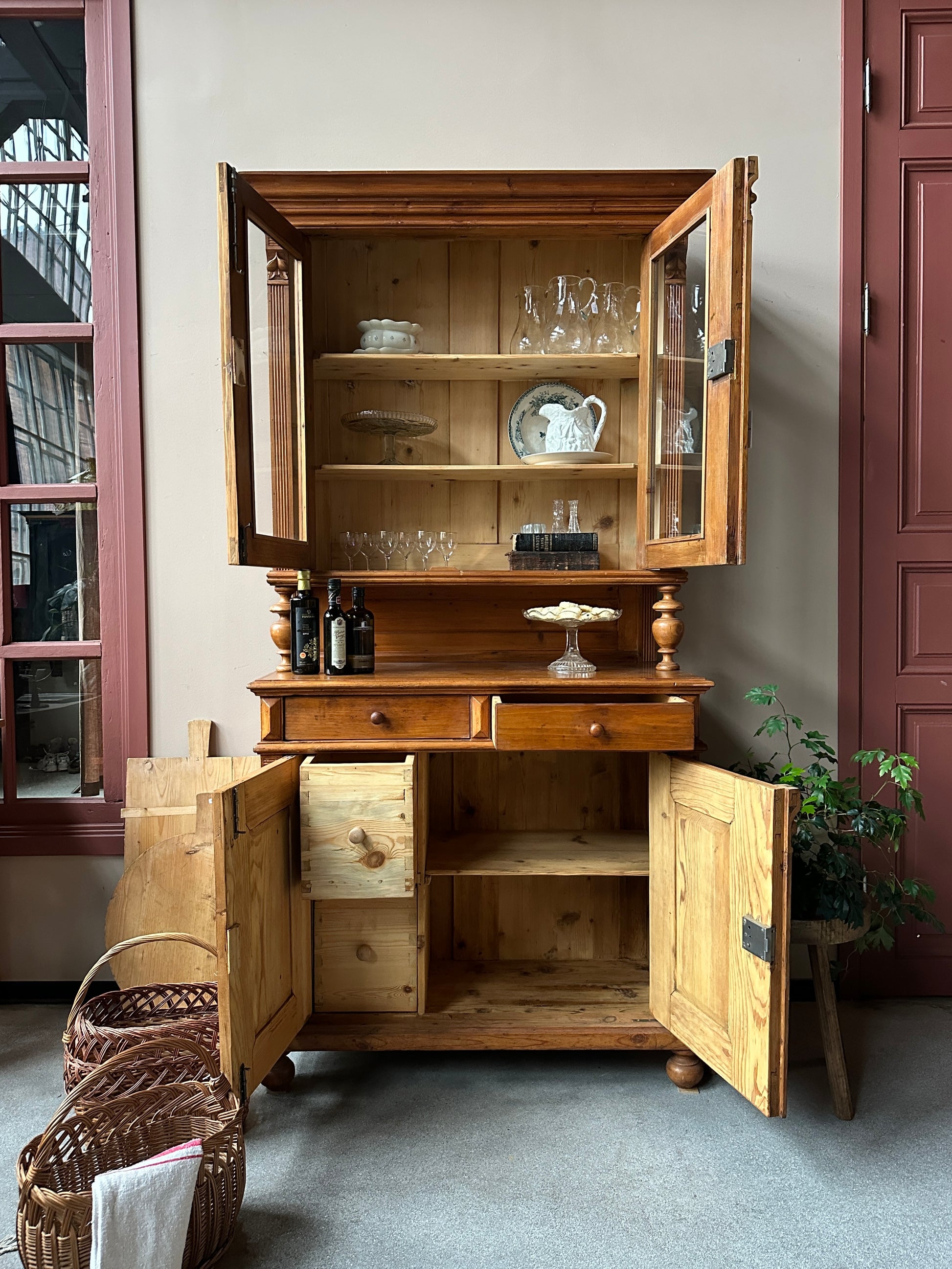 Trärent köksskåp mot ljus vägg. öppna dörrar