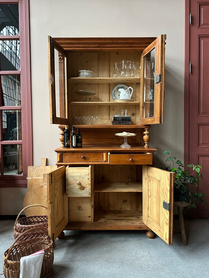 Trärent köksskåp mot ljus vägg. öppna dörrar