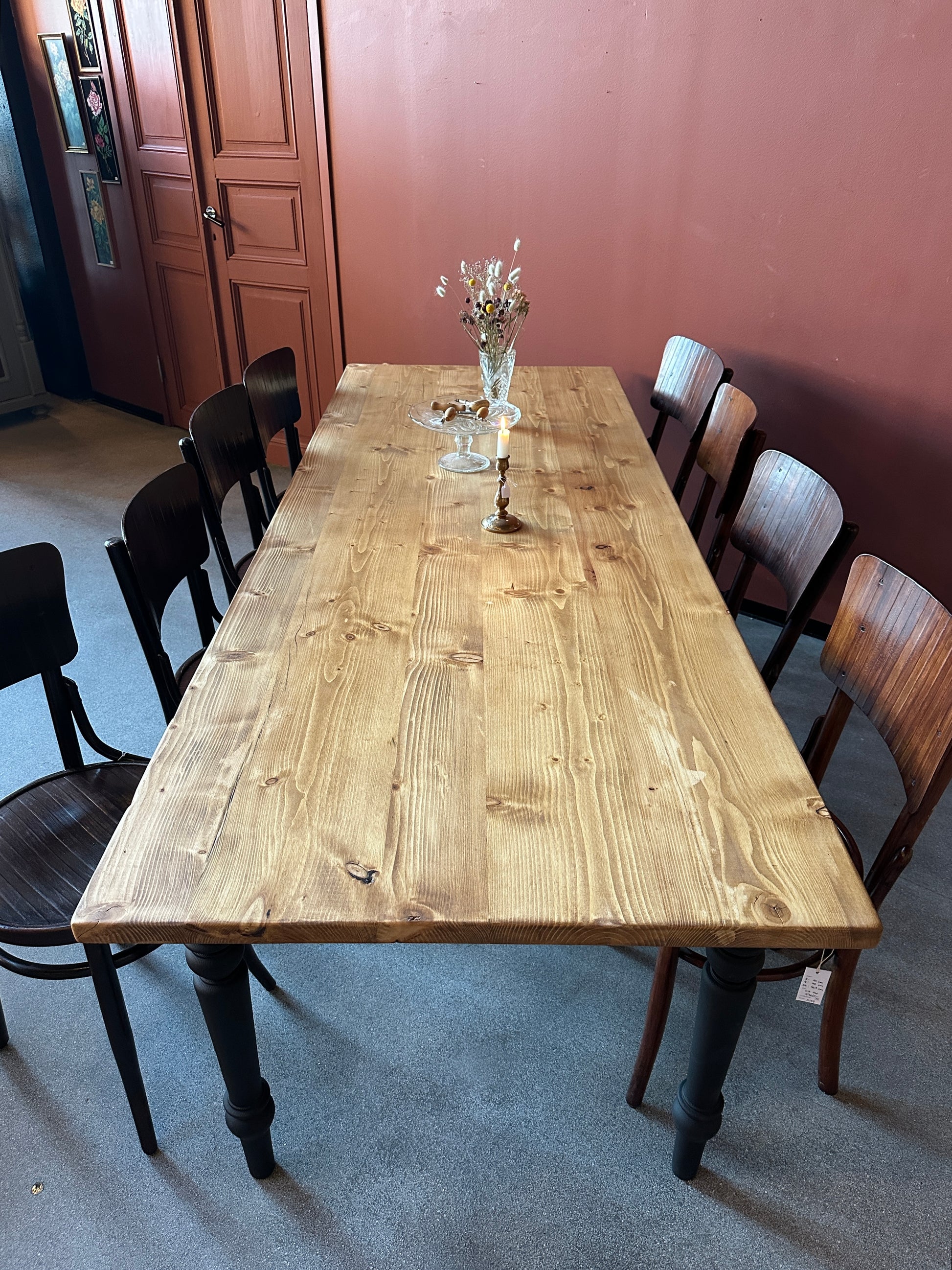 Ett vackert matbord med en bordsskiva av återvunnet trä och ett nytillverkat underrede med svarvade ben i furu.